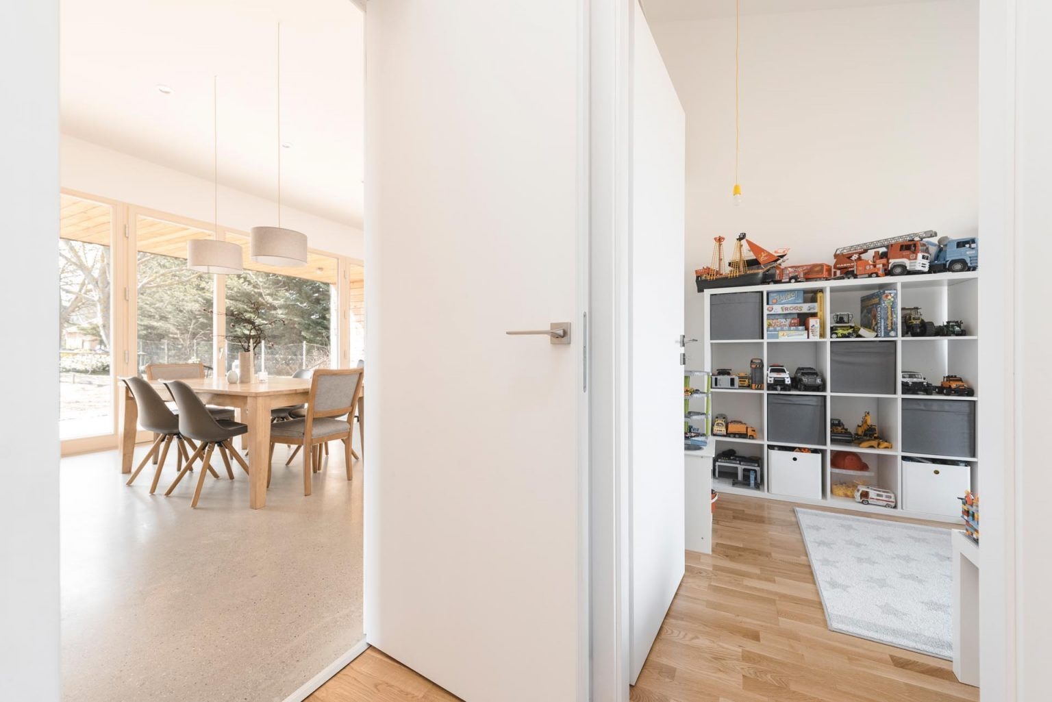Off the dining area, a playroom creates a dedicated space for the children while still remaining visually linked to the main living area.
