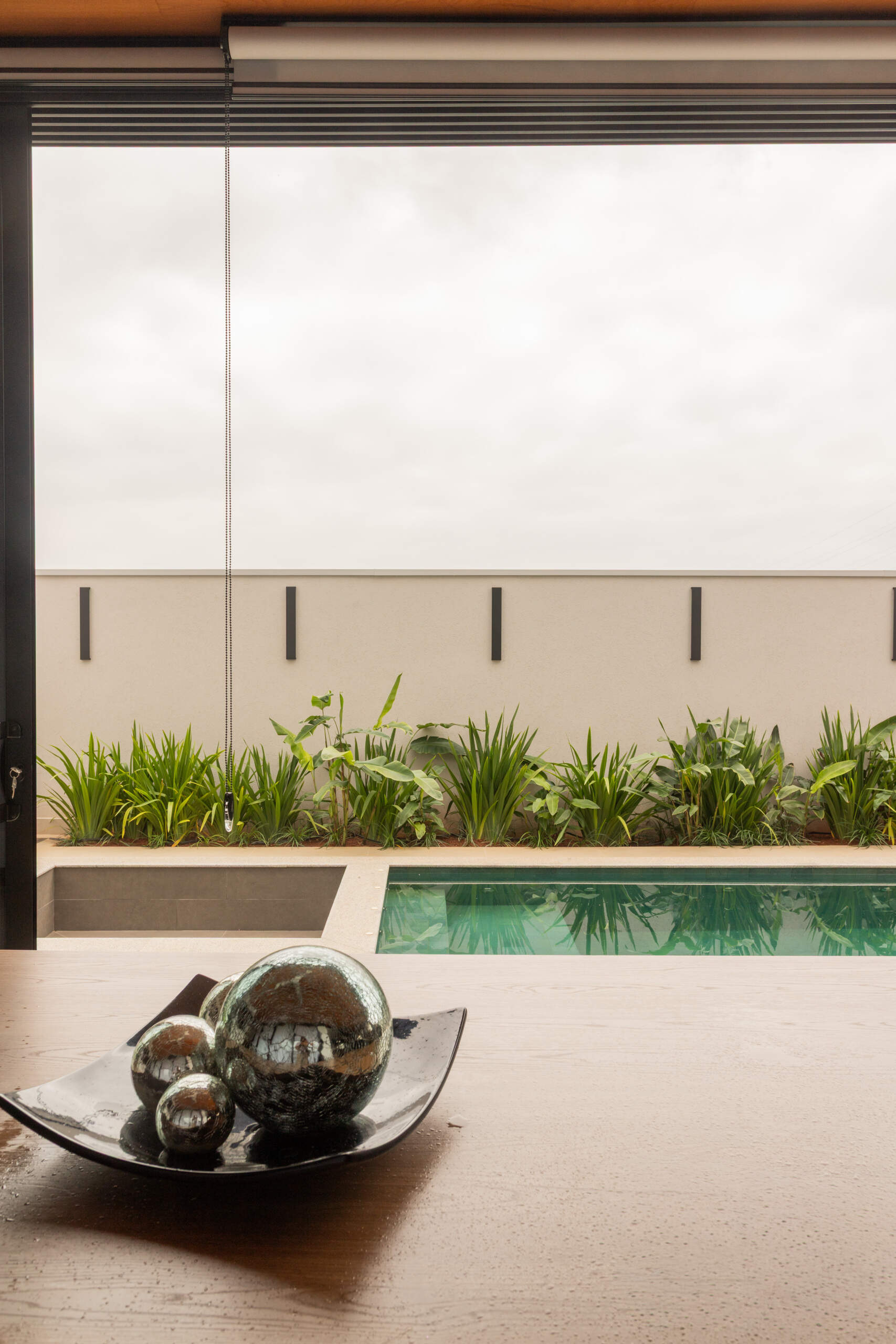 This contemporary pool area reflects the sculptural geometry of Casa R|L, featuring clean lines, concrete textures, and modern outdoor living in Brazil.