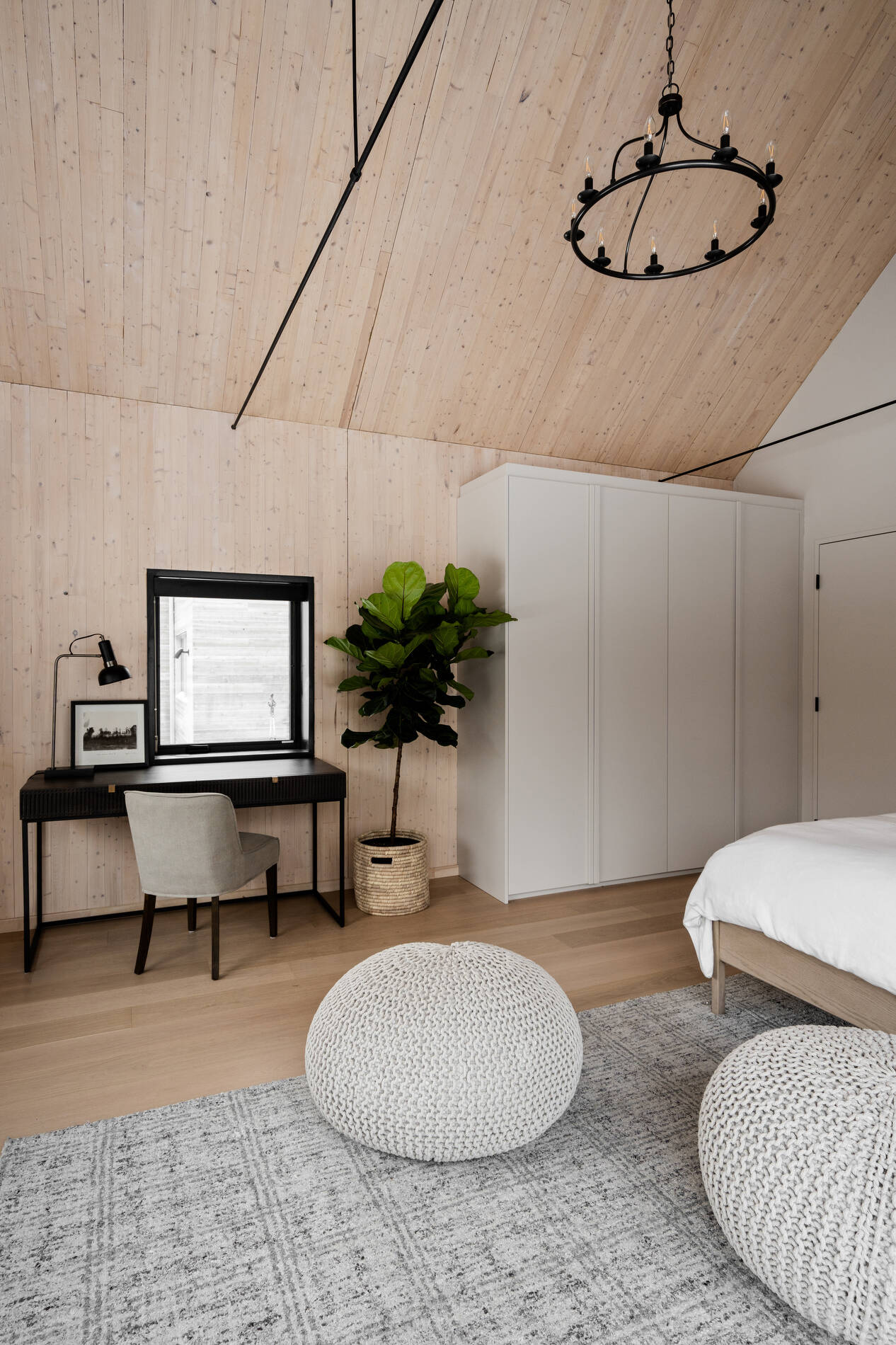 A private primary suite with timber interiors and large windows, offering a quiet connection to the surrounding landscape.