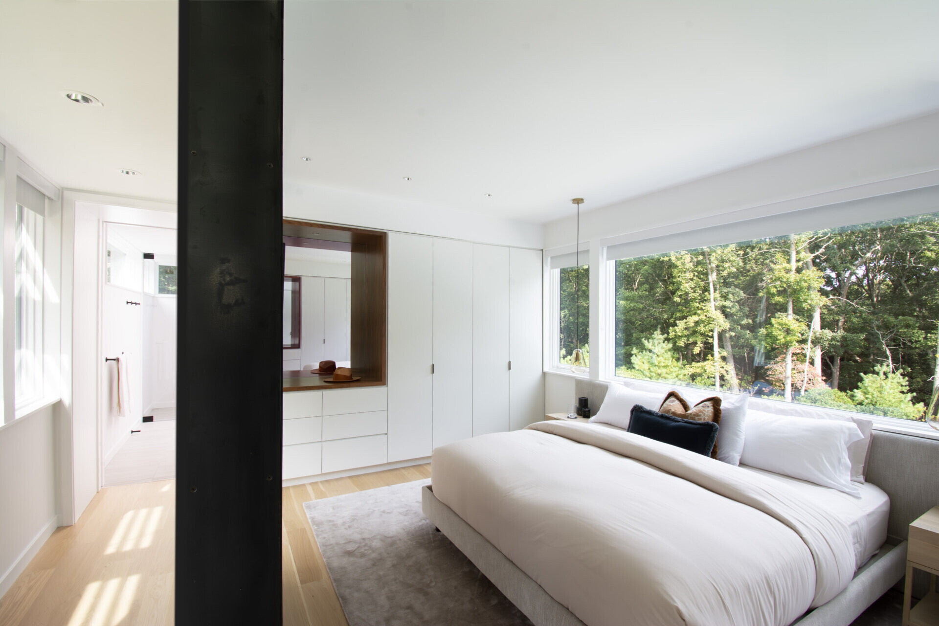 Soft natural finishes and expansive glazing make this bedroom feel open to the surrounding landscape.