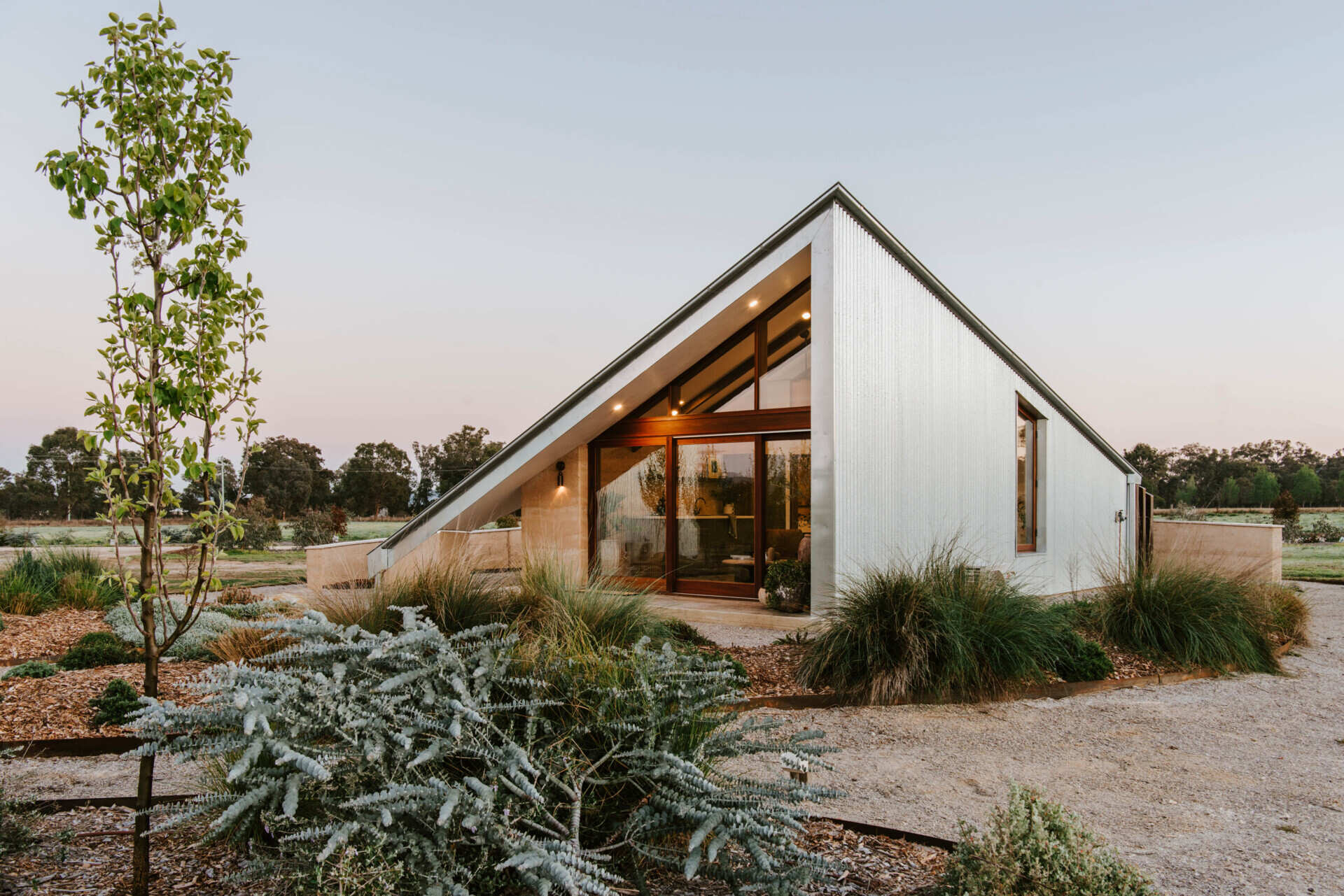 Compact off-grid cabins in Mudgee designed with rammed earth, timber, and a folded roof that reimagines camping through architecture.