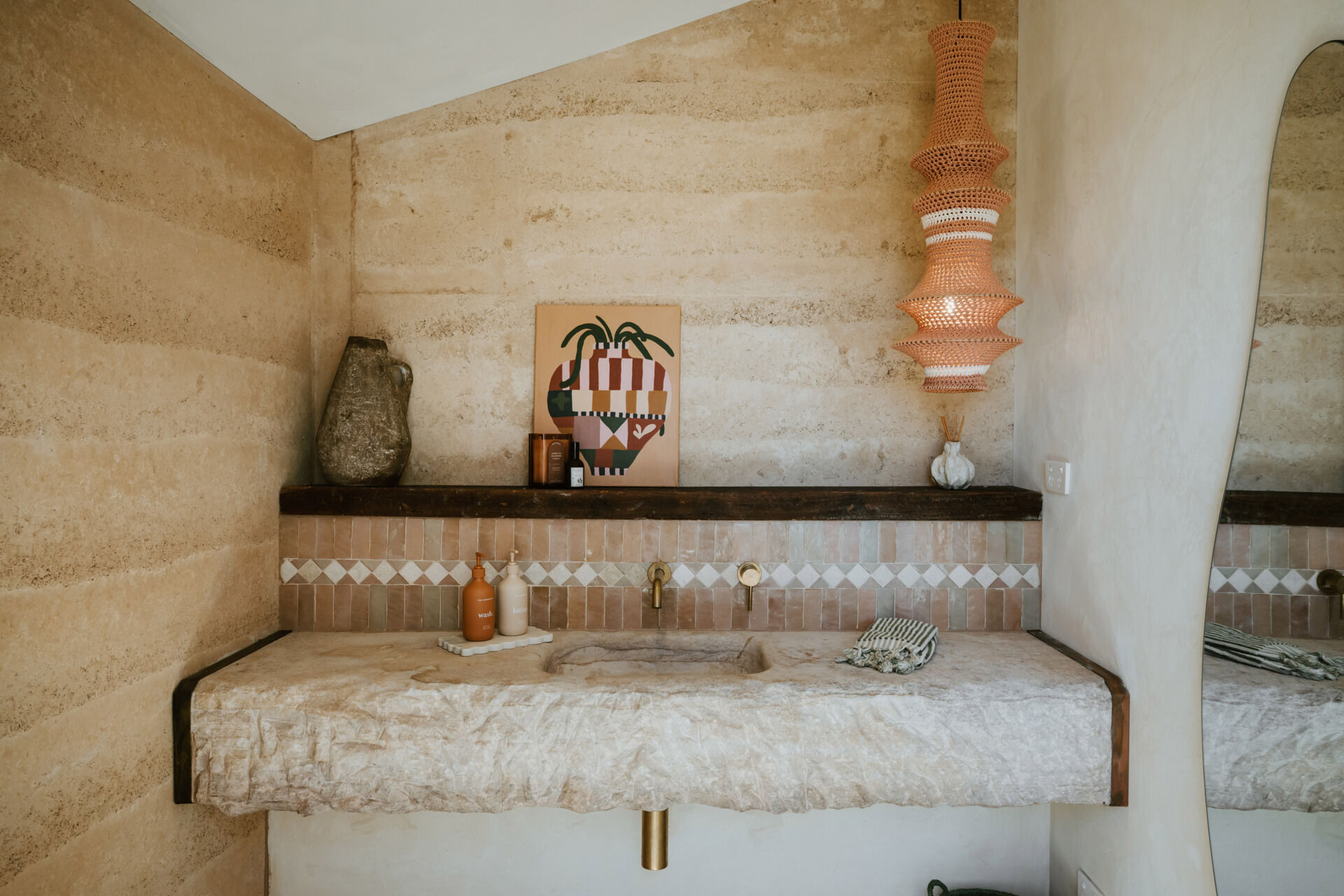 The interiors of a compact off-grid cabin designed with rammed earth, timber, and a folded roof that reimagines camping through architecture.