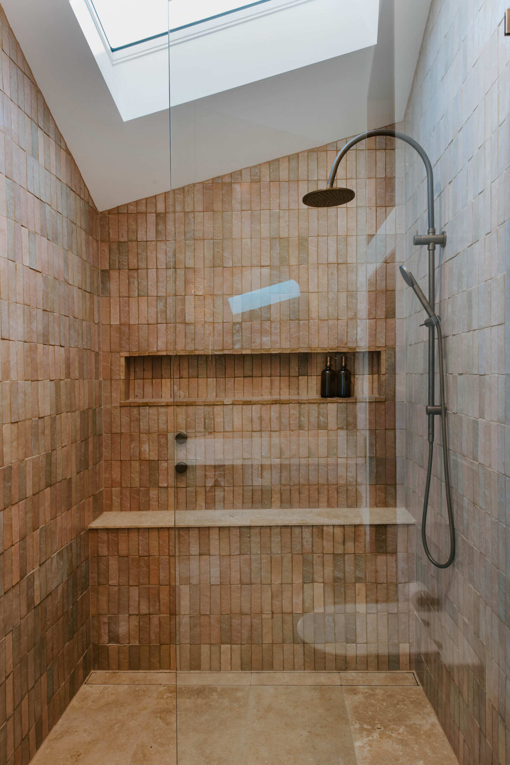 The interiors of a compact off-grid cabin designed with rammed earth, timber, and a folded roof that reimagines camping through architecture.