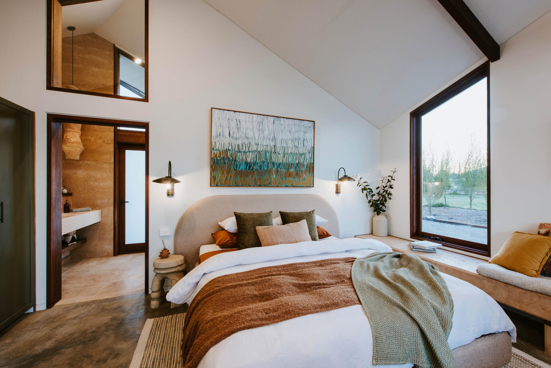 The interiors of a compact off-grid cabin designed with rammed earth, timber, and a folded roof that reimagines camping through architecture.