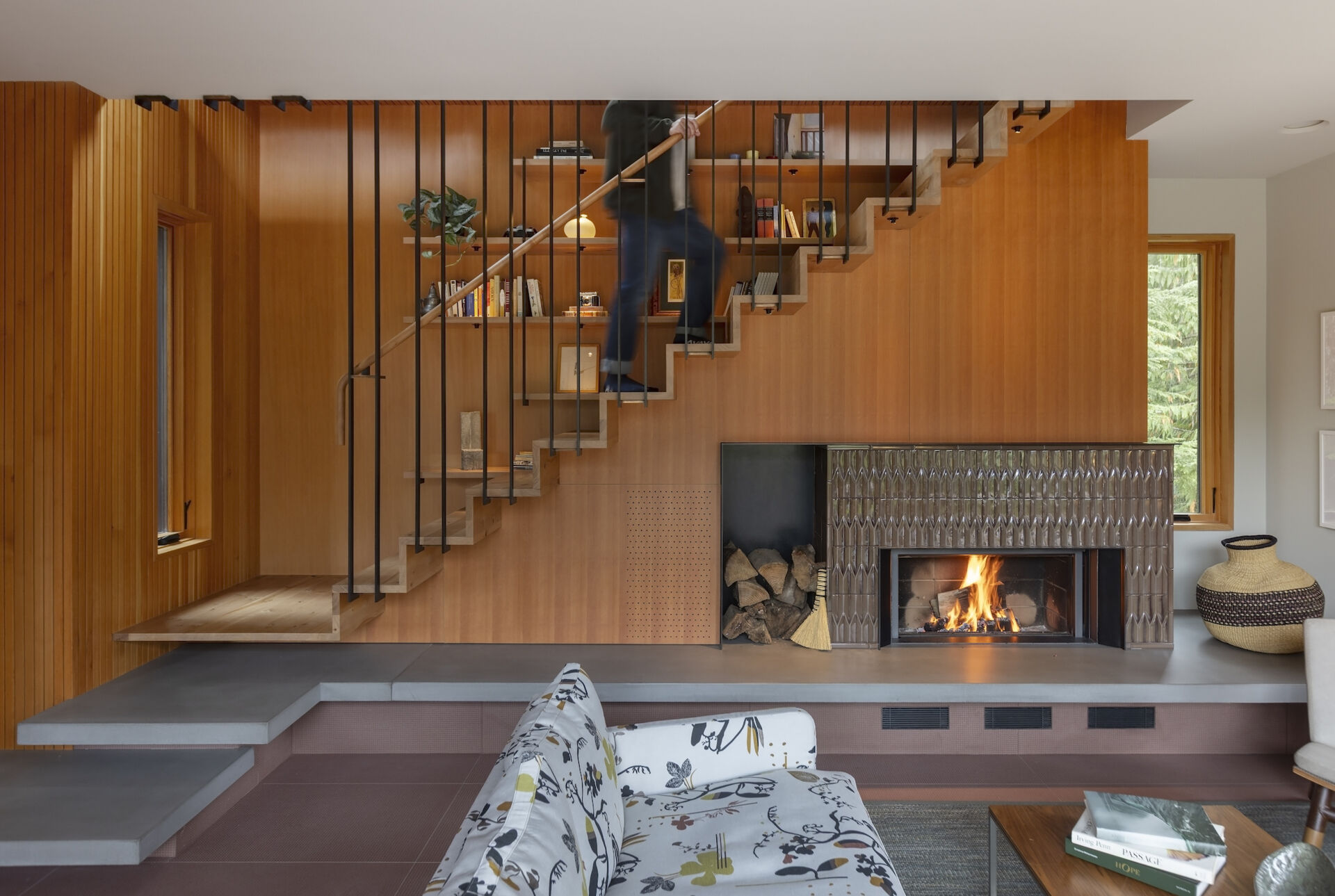 Floating madrone stairs, built-in shelving, and a ceramic fireplace turn this living room into a functional work of art.