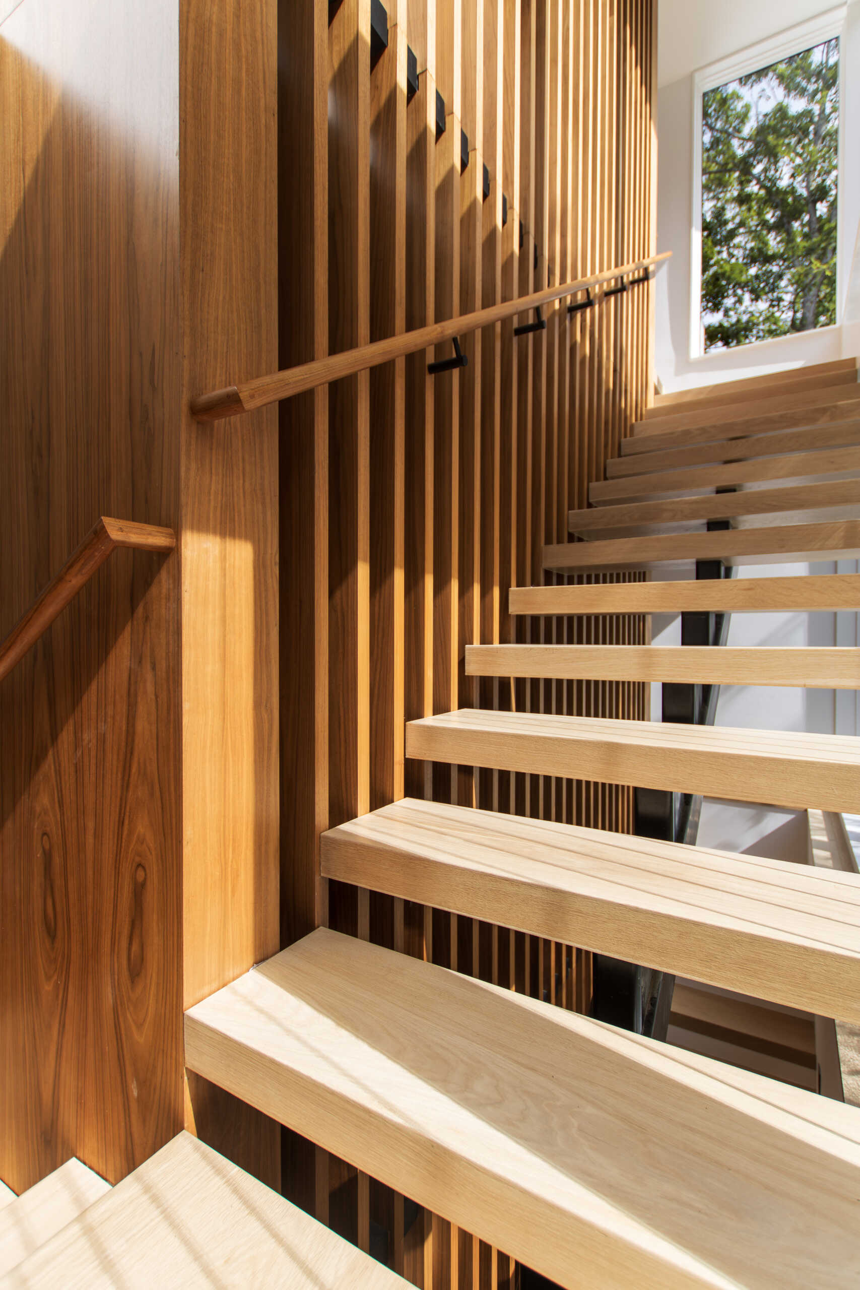 Front and rear staircases acts as both a circulation path and a source of natural light. As sunlight changes through the day, shadows move across the stair walls and flooring, turning the vertical circulation space into one of the most visually dynamic areas of the home.