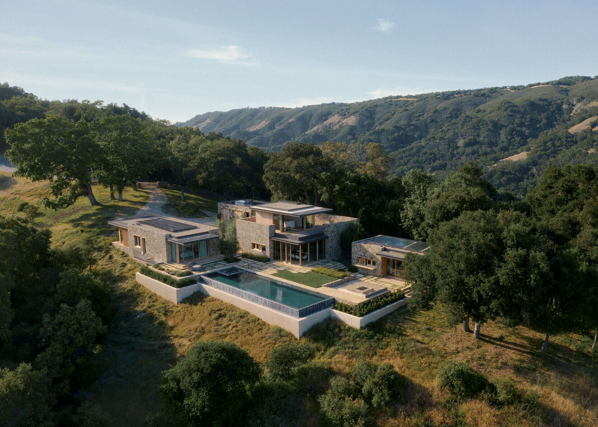 Four separate stone pavilions step across the California hillside, creating a modern villa layout inspired by Tuscan villages and open-air living.