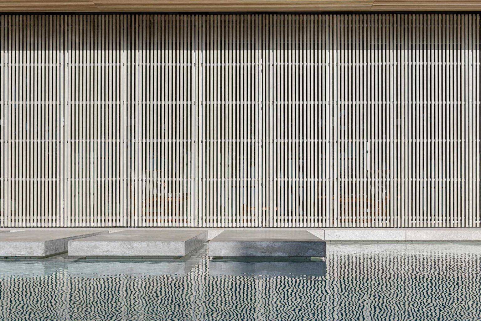 Traditional wooden shutters filter sunlight through narrow timber slats, creating beautiful shadow patterns inside the home.