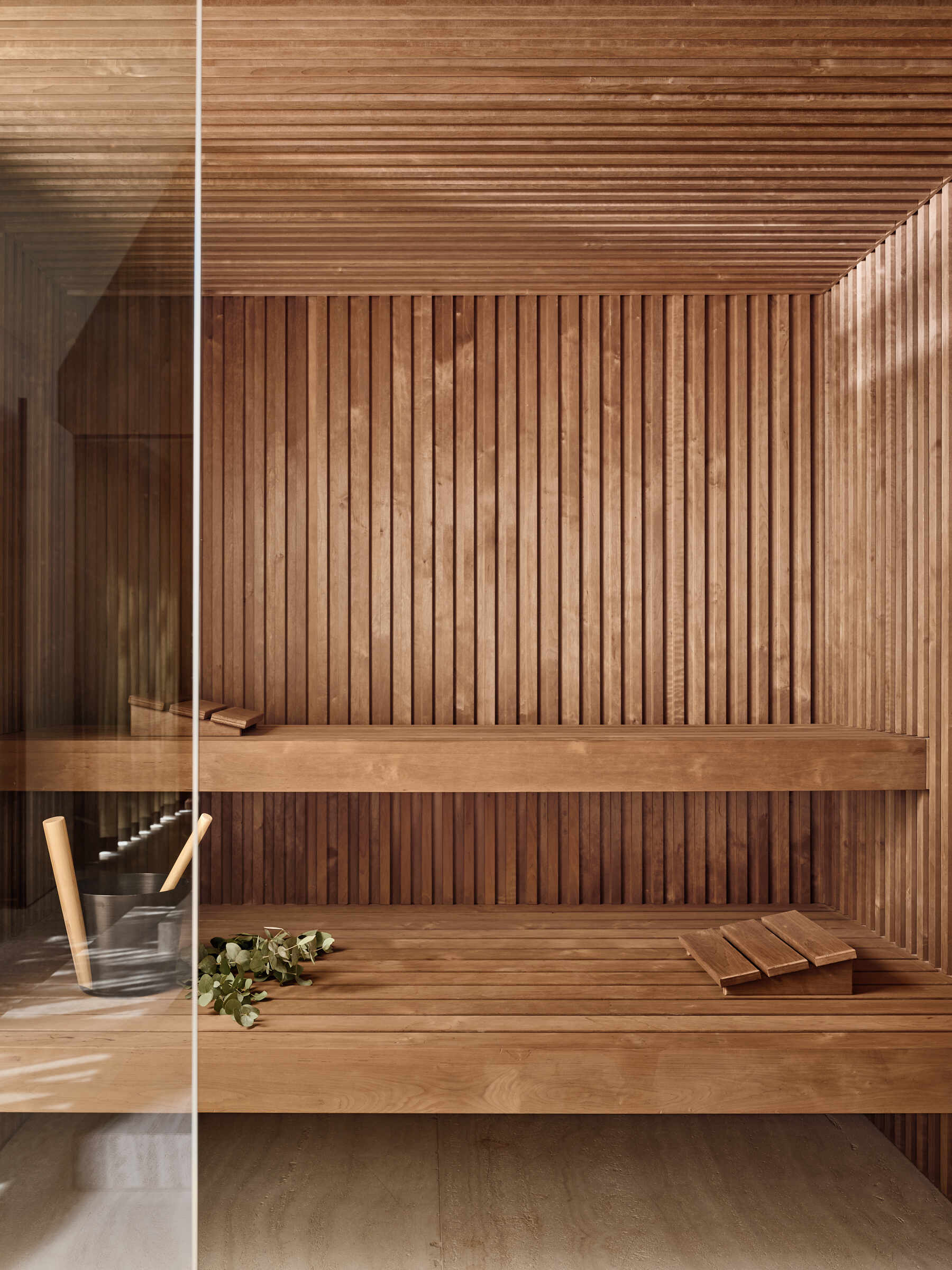 Travertine walls, a garden-facing jacuzzi, and sculptural lounge furniture turn this wellness wing into a luxurious escape at home.