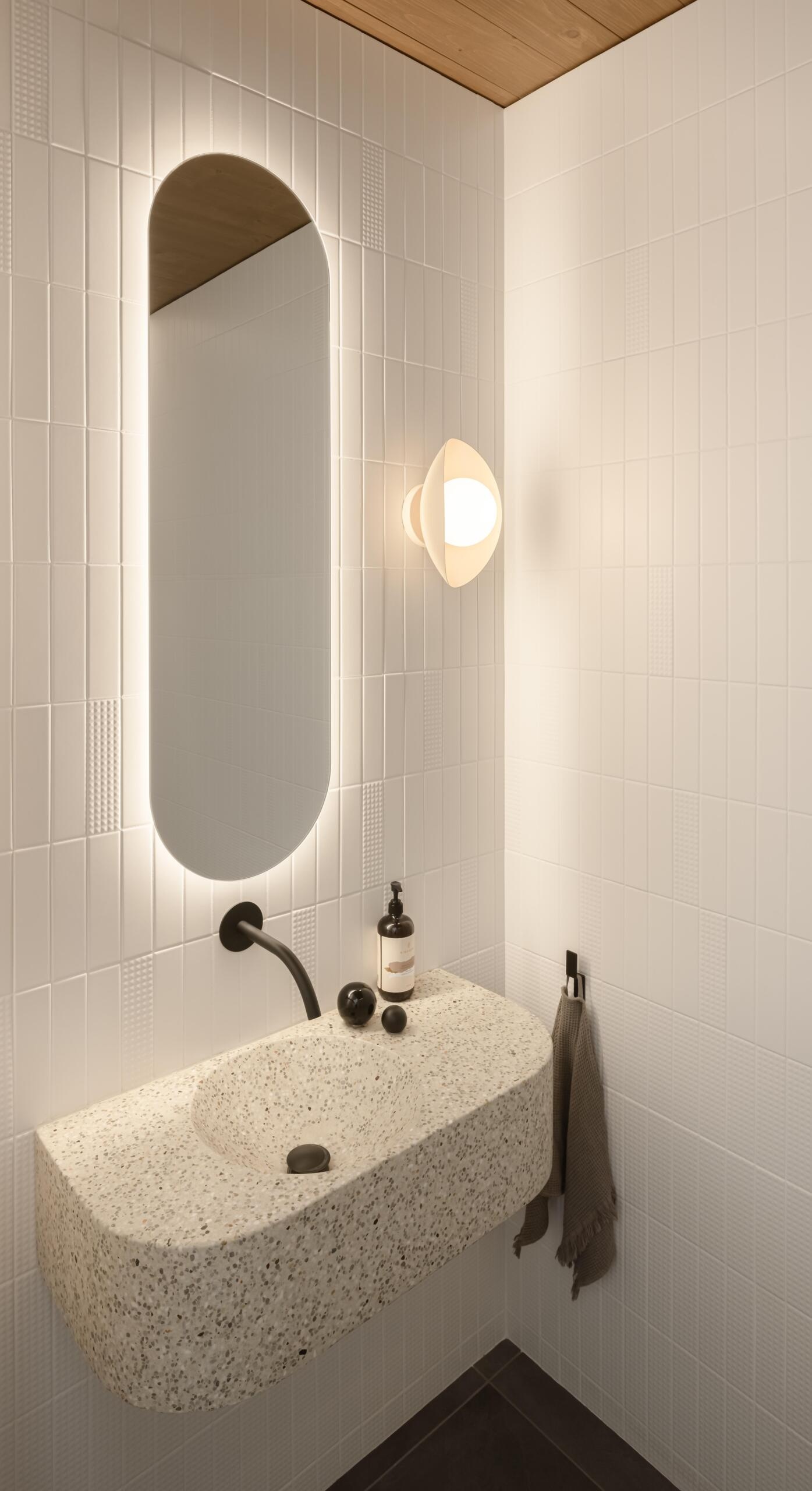 Refined finishes and sculptural details give this modern powder room a surprisingly dramatic architectural presence.