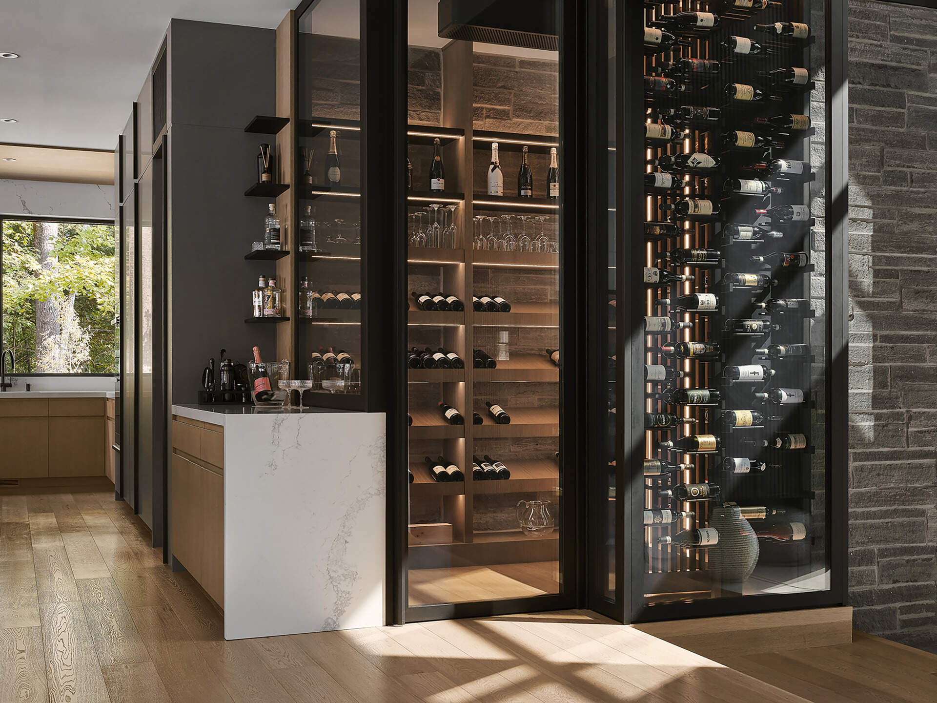 A dramatic glass wine room becomes the centerpiece of this contemporary home, displaying bottles like a modern architectural library.