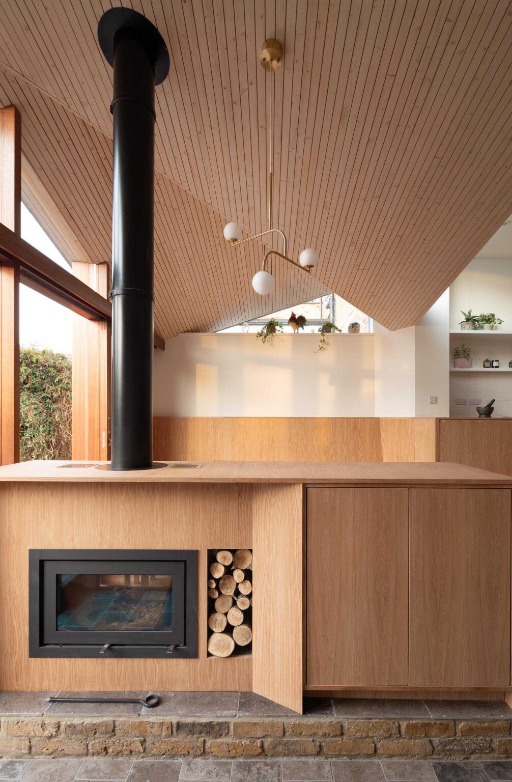 A hidden fireplace and TV cabinet subtly separates the dining room and snug in this modern family addition.