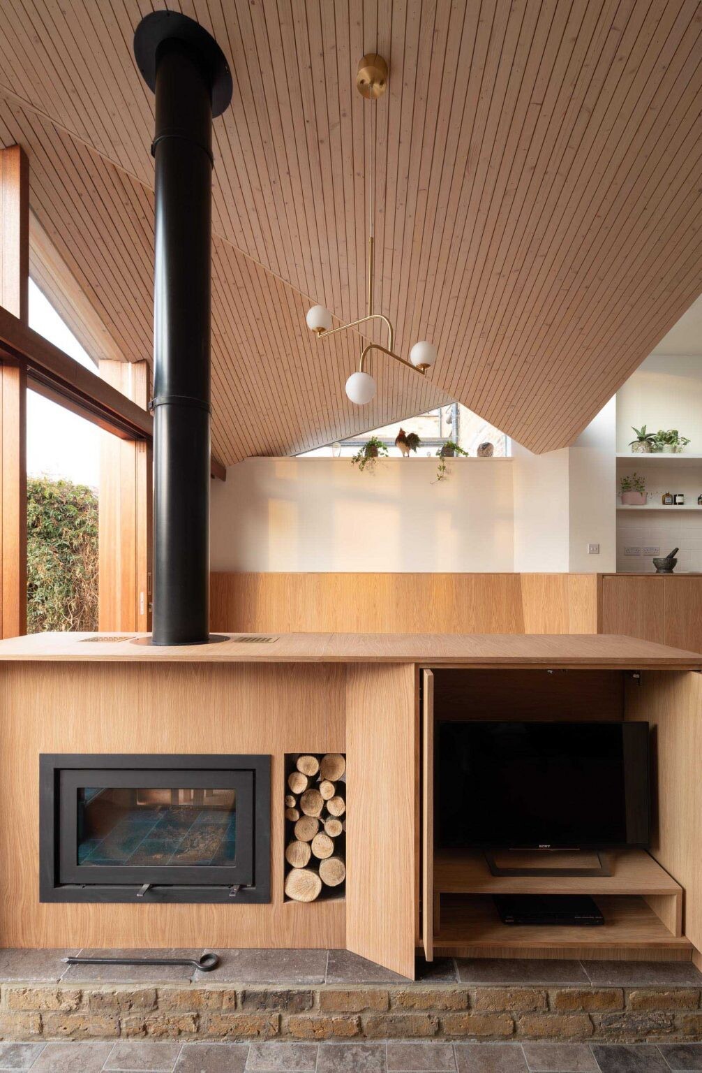 A hidden fireplace and TV cabinet subtly separates the dining room and snug in this modern family addition.