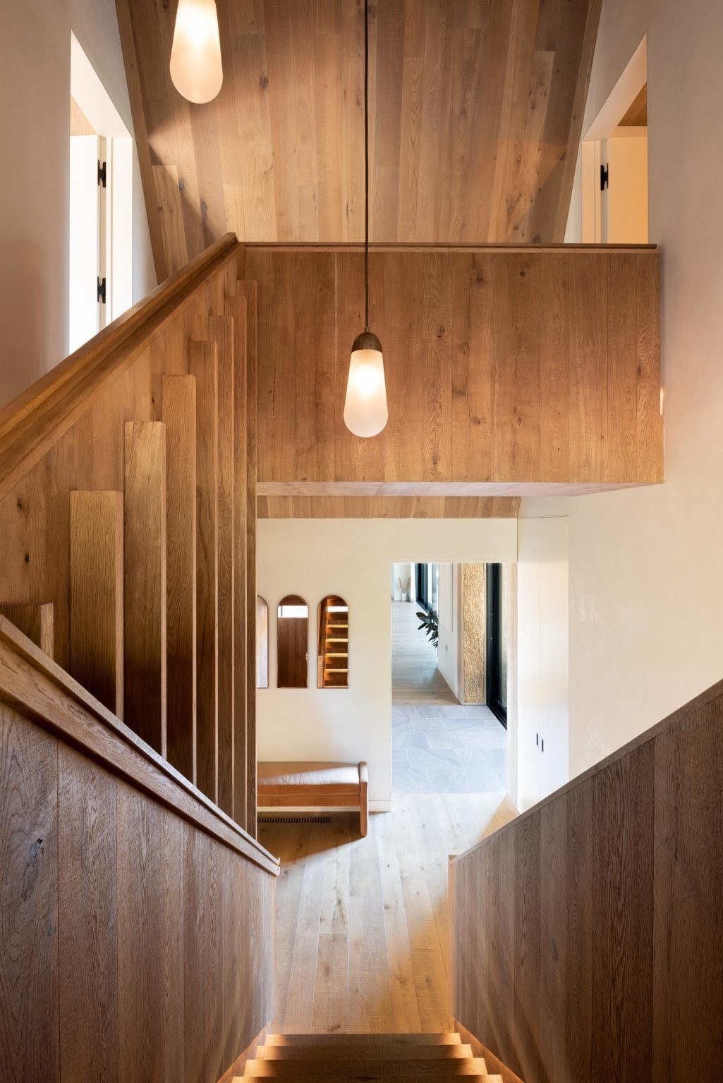 Wood stairs with hidden lighting connect the different levels of the house, adding a subtle sculptural element to the interior. The detailing feels refined while still maintaining the home’s relaxed atmosphere.