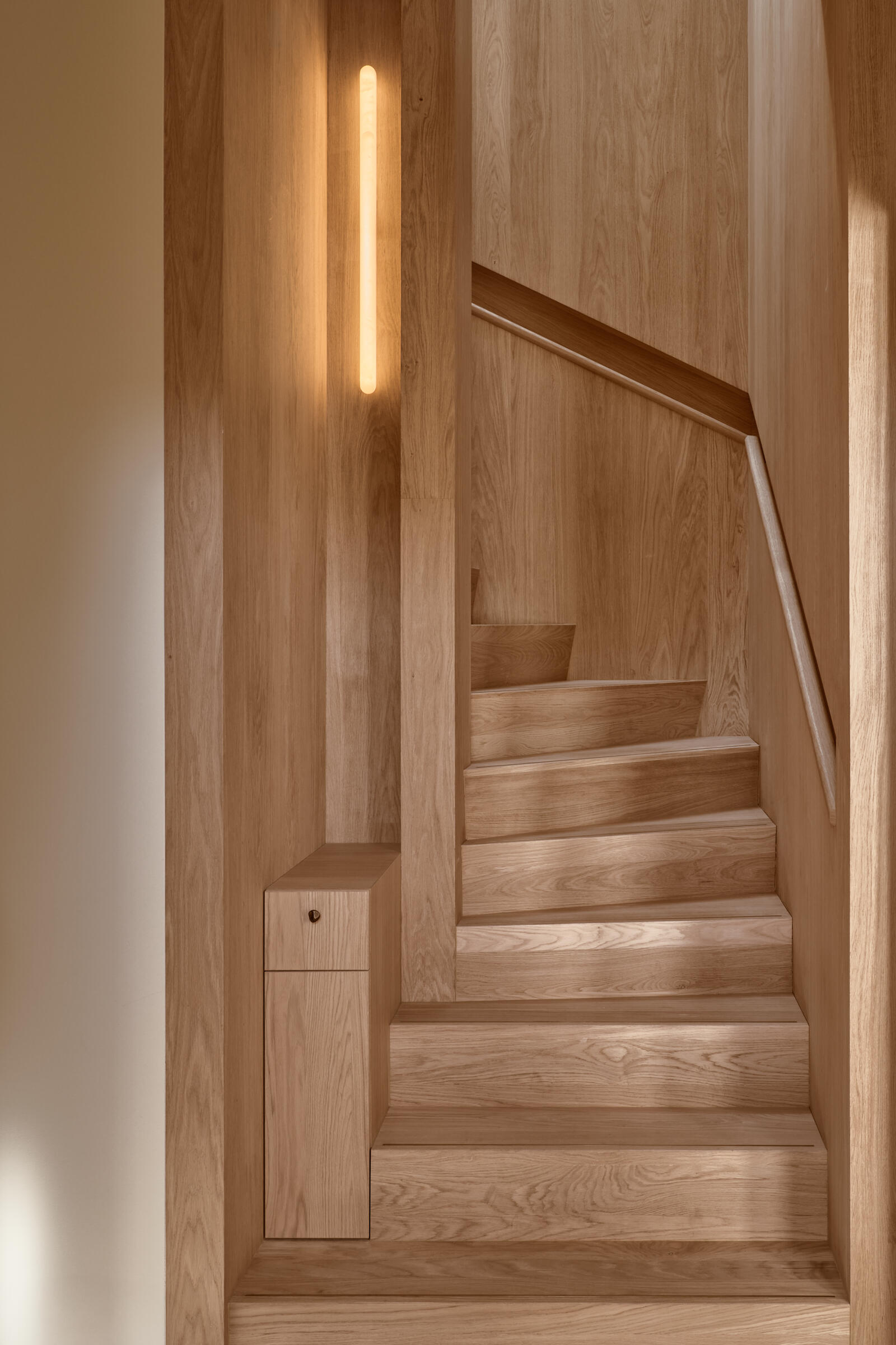 A skylight floods this sculptural staircase with natural light, creating one of the most striking architectural moments in the home.