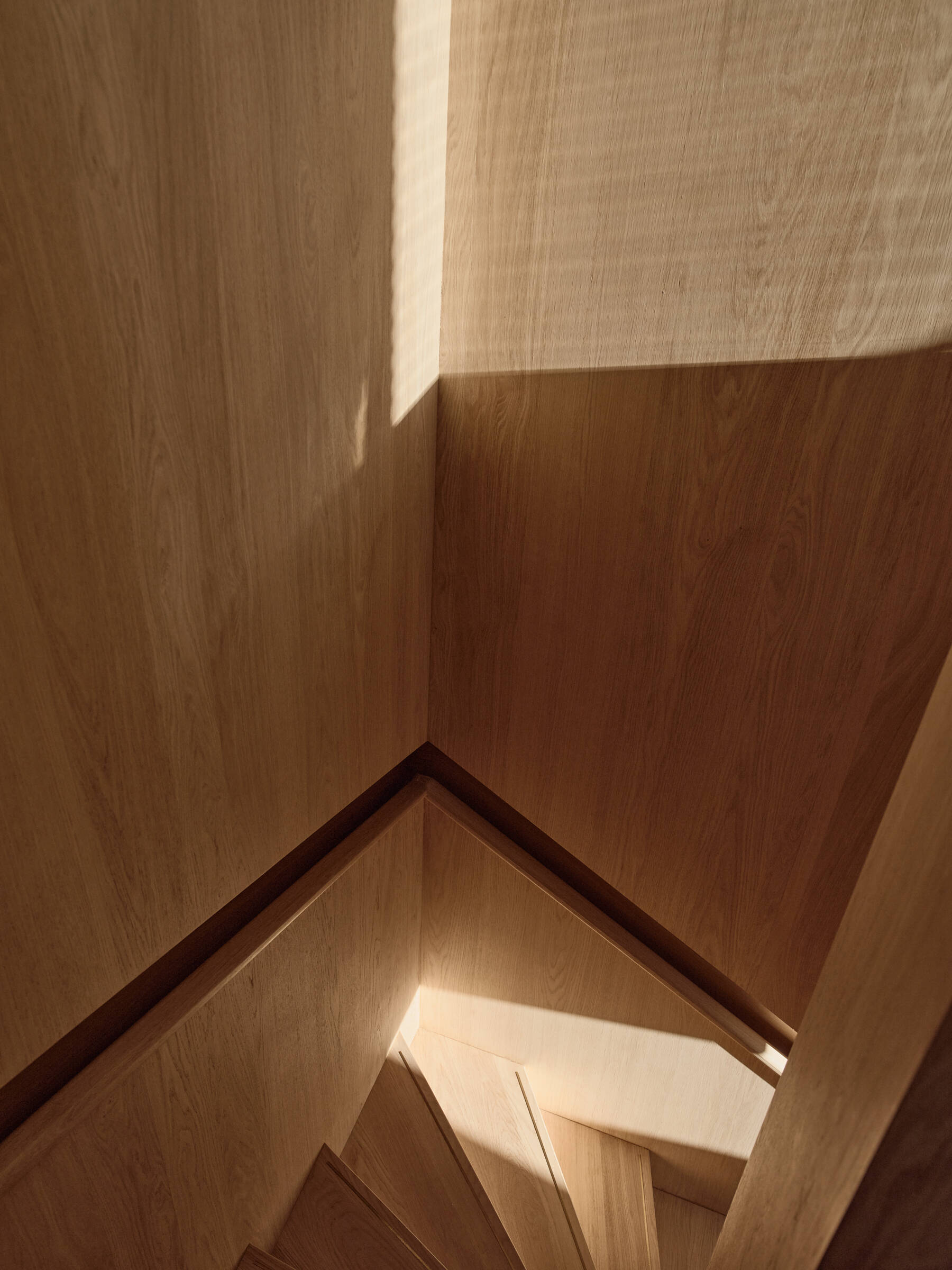 A skylight floods this sculptural staircase with natural light, creating one of the most striking architectural moments in the home.