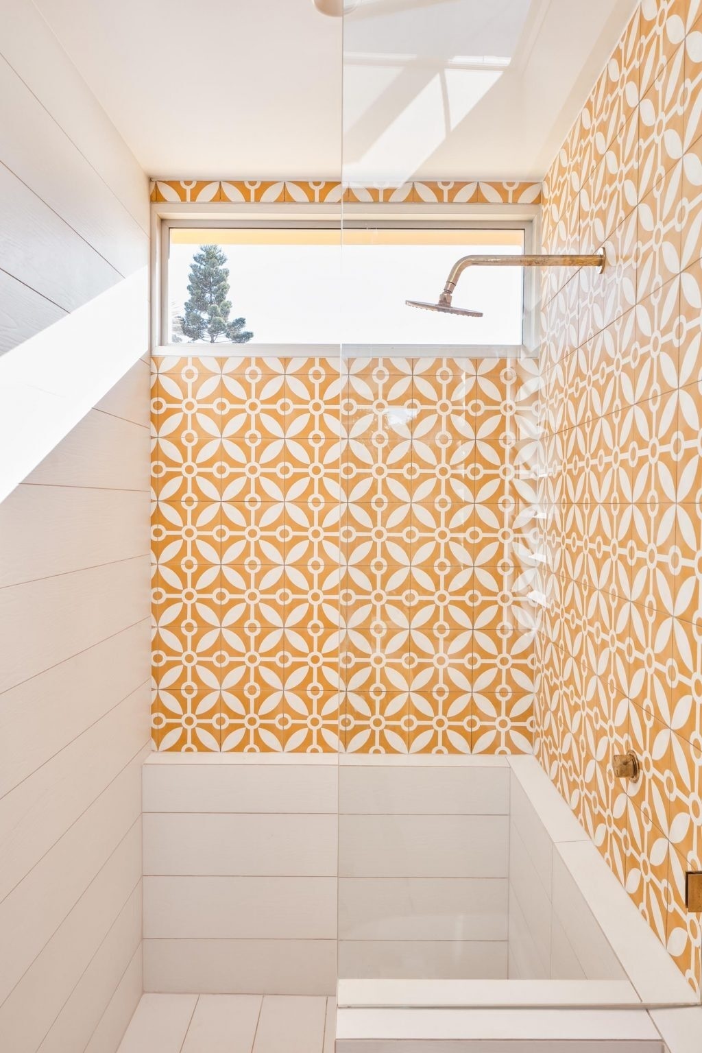 Patterned tiles, timber details, and a walk-in shower give this compact en-suite bathroom a stylish modern Australian look.