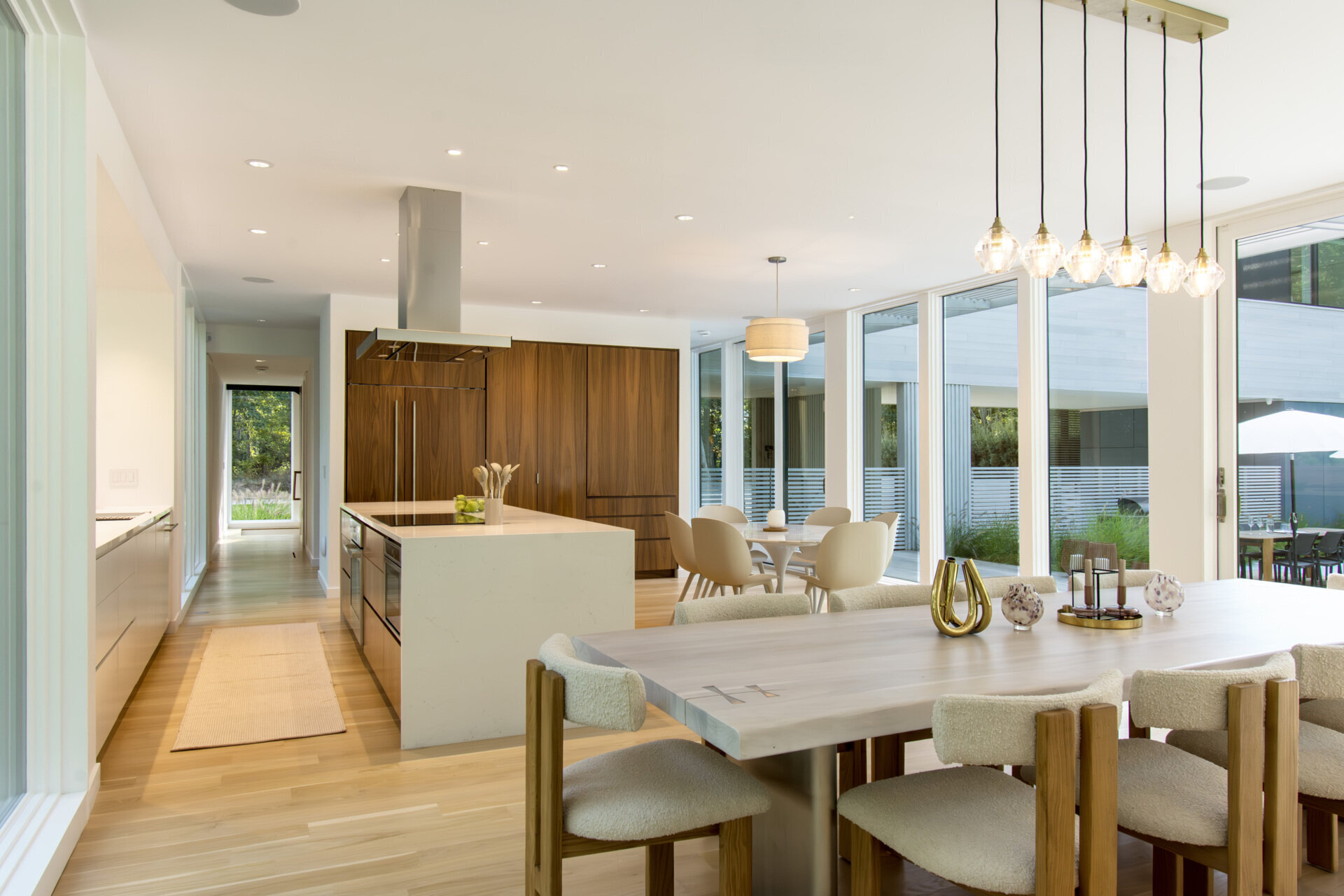 Natural light, forest views, and direct access to outdoor terraces define this bright contemporary dining space.