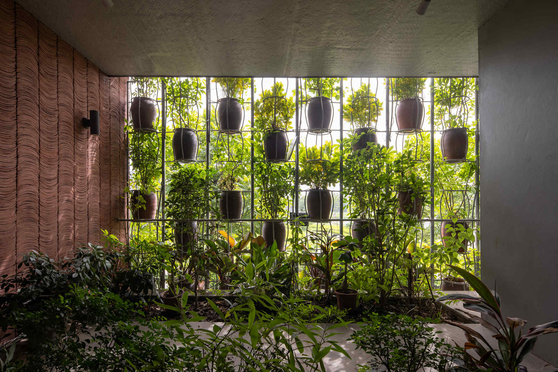 From inside, the planted facade transforms into a soft green filter that changes throughout the day.