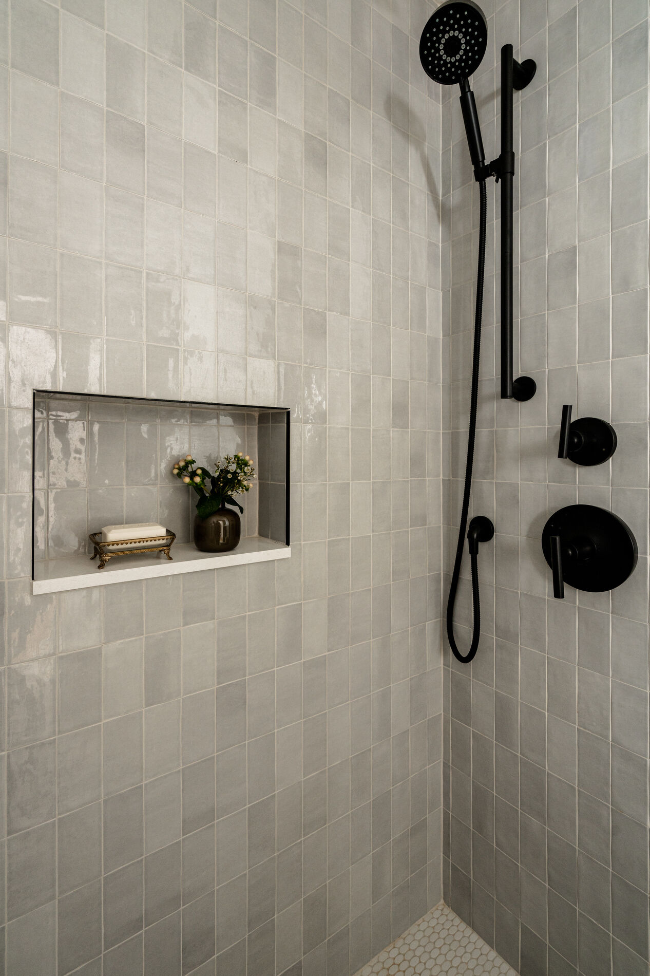 A modern bathroom with a built-in shelving niche in the shower.