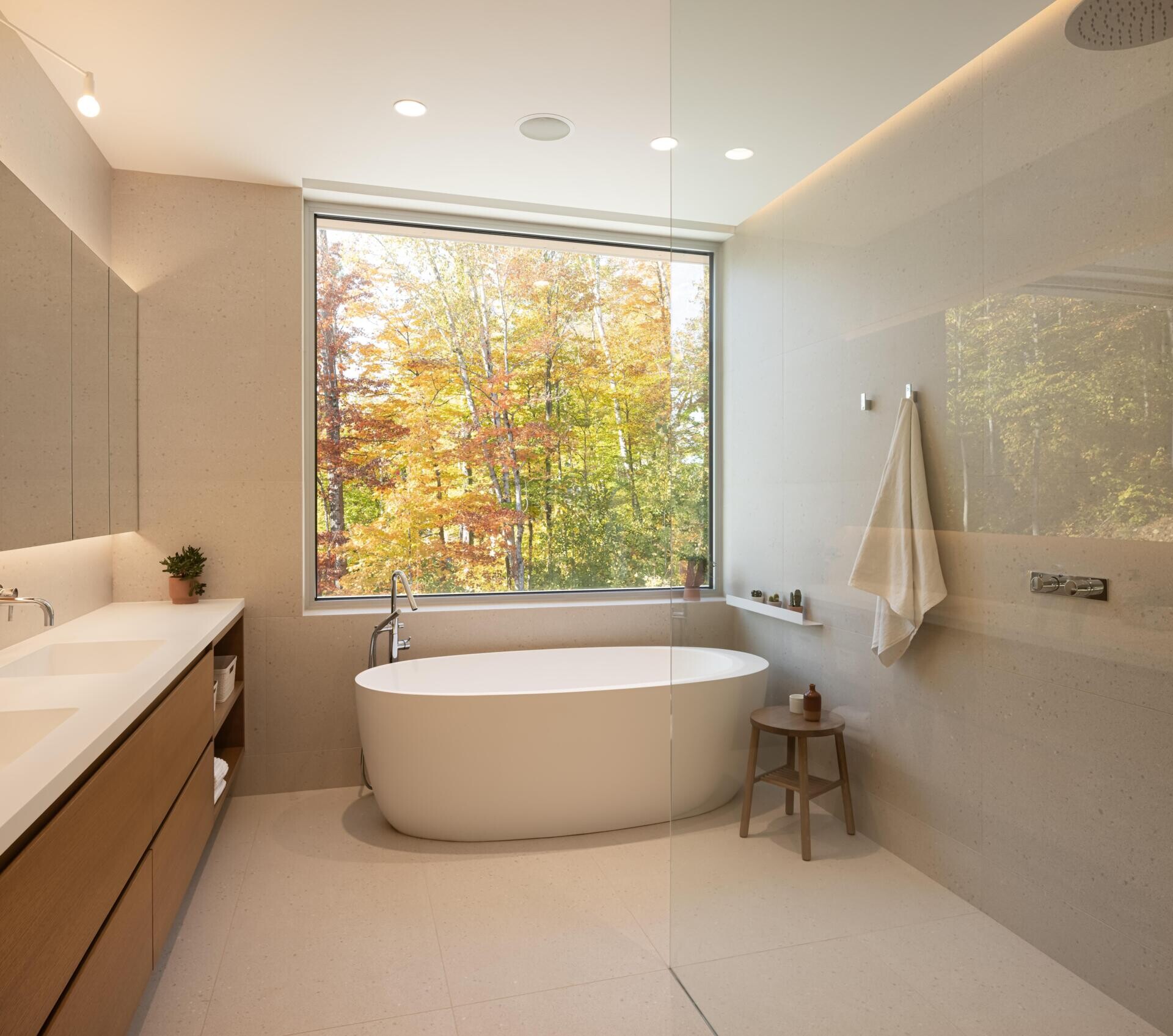 Positioned like a suspended volume above the landscape, the primary quarters include a bedroom, bathroom, office, meditation room, and walk-in closet. Large windows keep the scenery constantly present, while the warm wood palette adds softness and comfort.