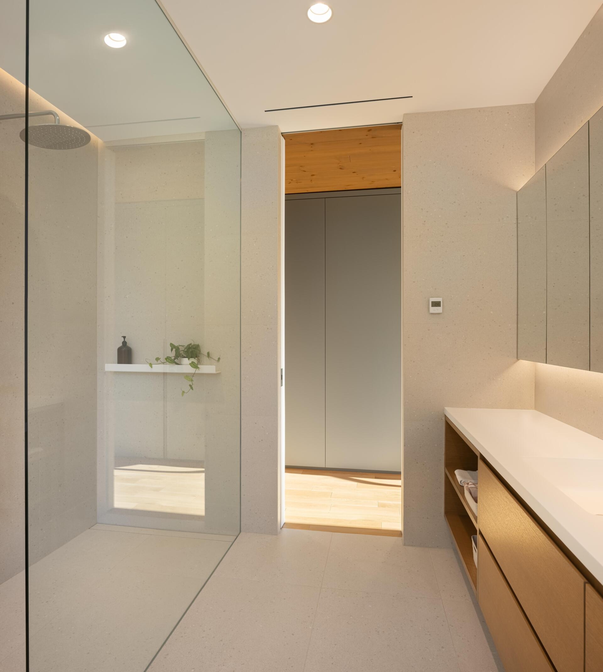 Positioned like a suspended volume above the landscape, the primary quarters include a bedroom, bathroom, office, meditation room, and walk-in closet. Large windows keep the scenery constantly present, while the warm wood palette adds softness and comfort.