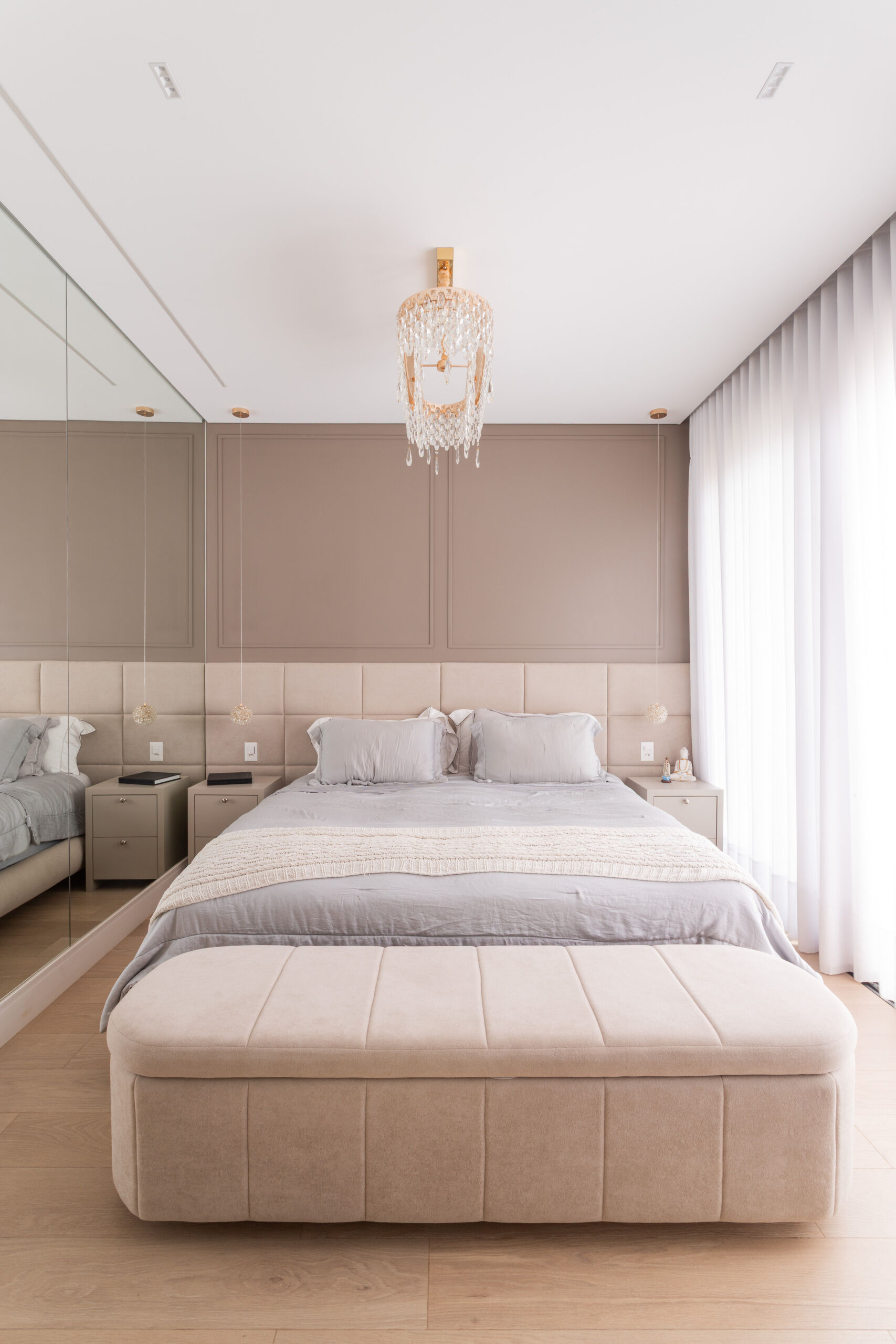 The primary bedroom in Casa R|L pairs mirrors, warm textures, natural light, and contemporary architecture inside this sophisticated Brazilian home.