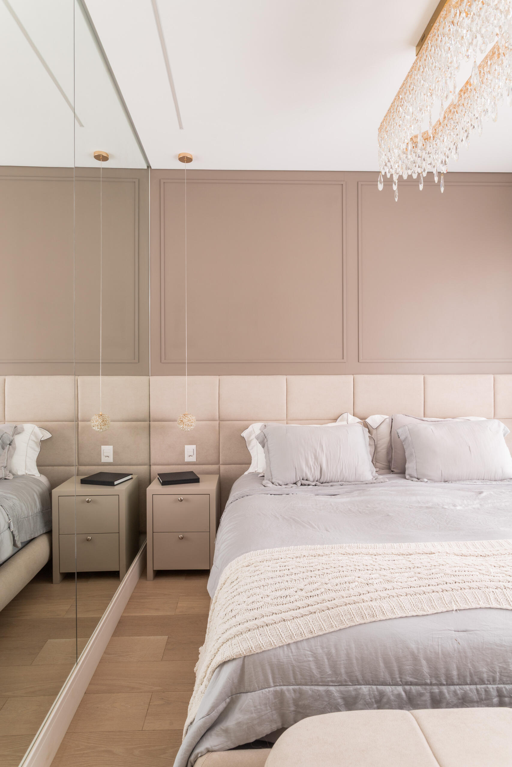 The primary bedroom in Casa R|L pairs mirrors, warm textures, natural light, and contemporary architecture inside this sophisticated Brazilian home.