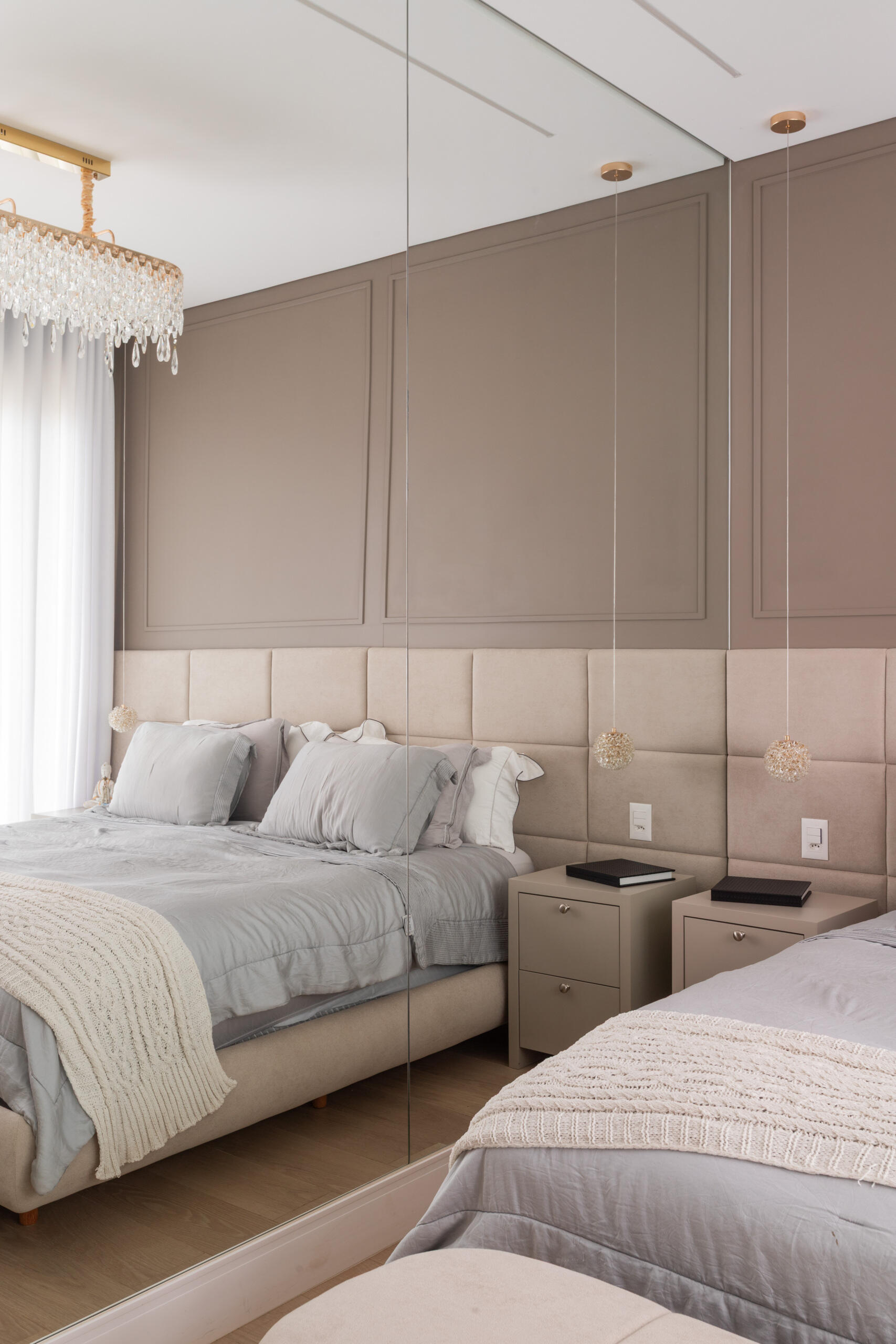 The primary bedroom in Casa R|L pairs mirrors, warm textures, natural light, and contemporary architecture inside this sophisticated Brazilian home.