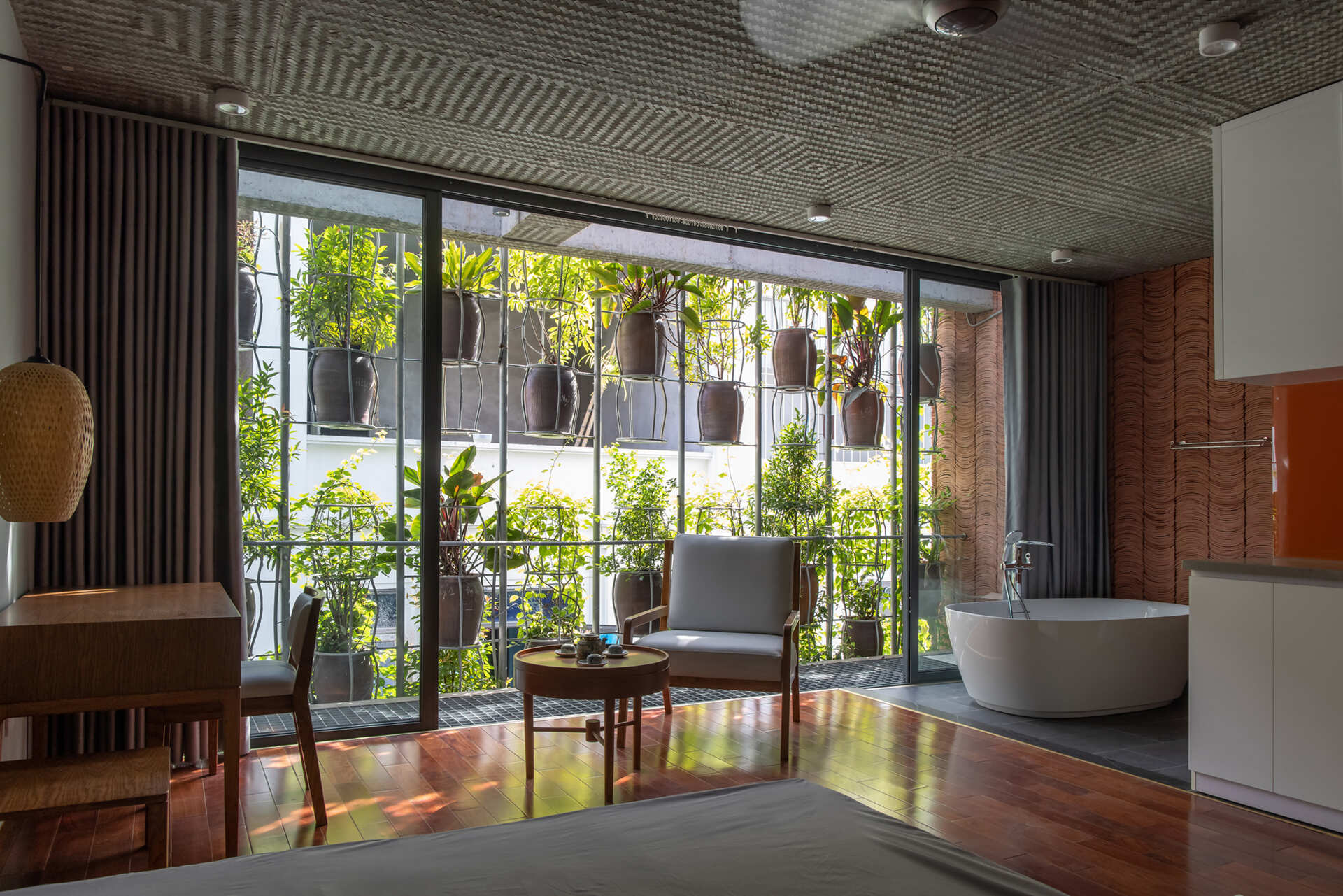 Private rooms maintain a simple material palette while staying visually connected to the planted exterior.