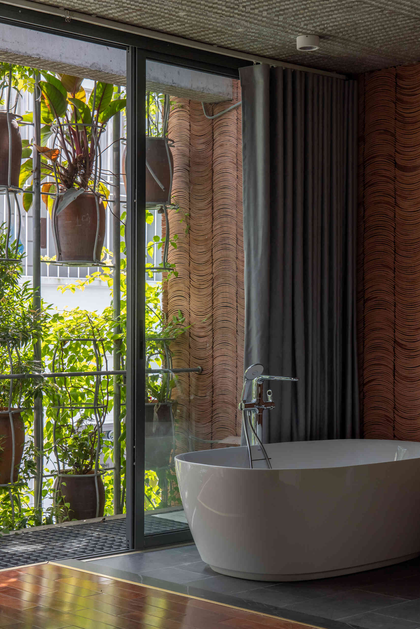Private rooms maintain a simple material palette while staying visually connected to the planted exterior.