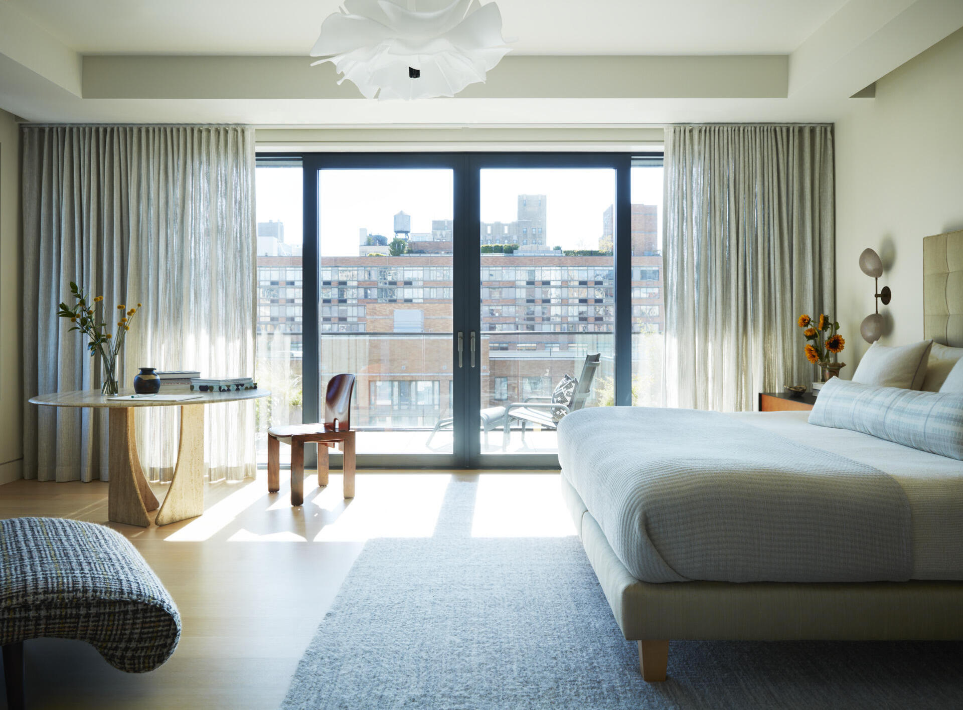 Mohair textures, vintage furniture, and sculptural lighting create a warm and elegant primary bedroom.