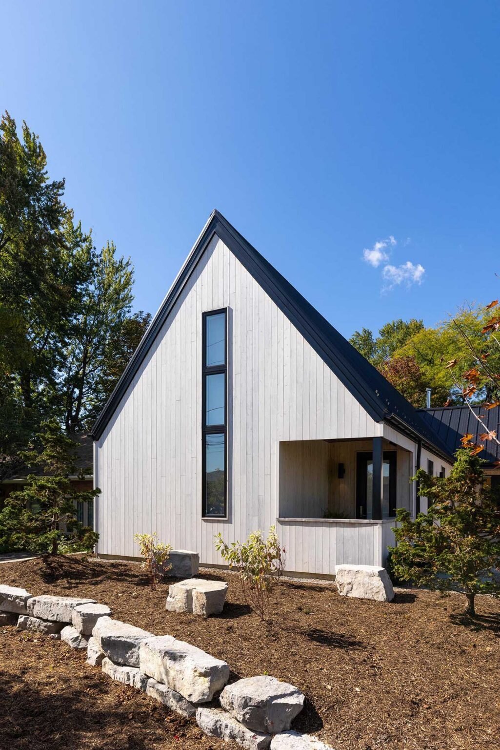 A modern Scandinavian-inspired home in Windsor, Ontario uses three clean-lined volumes to organize living, sleeping, and garage spaces into a striking J-shaped layout.