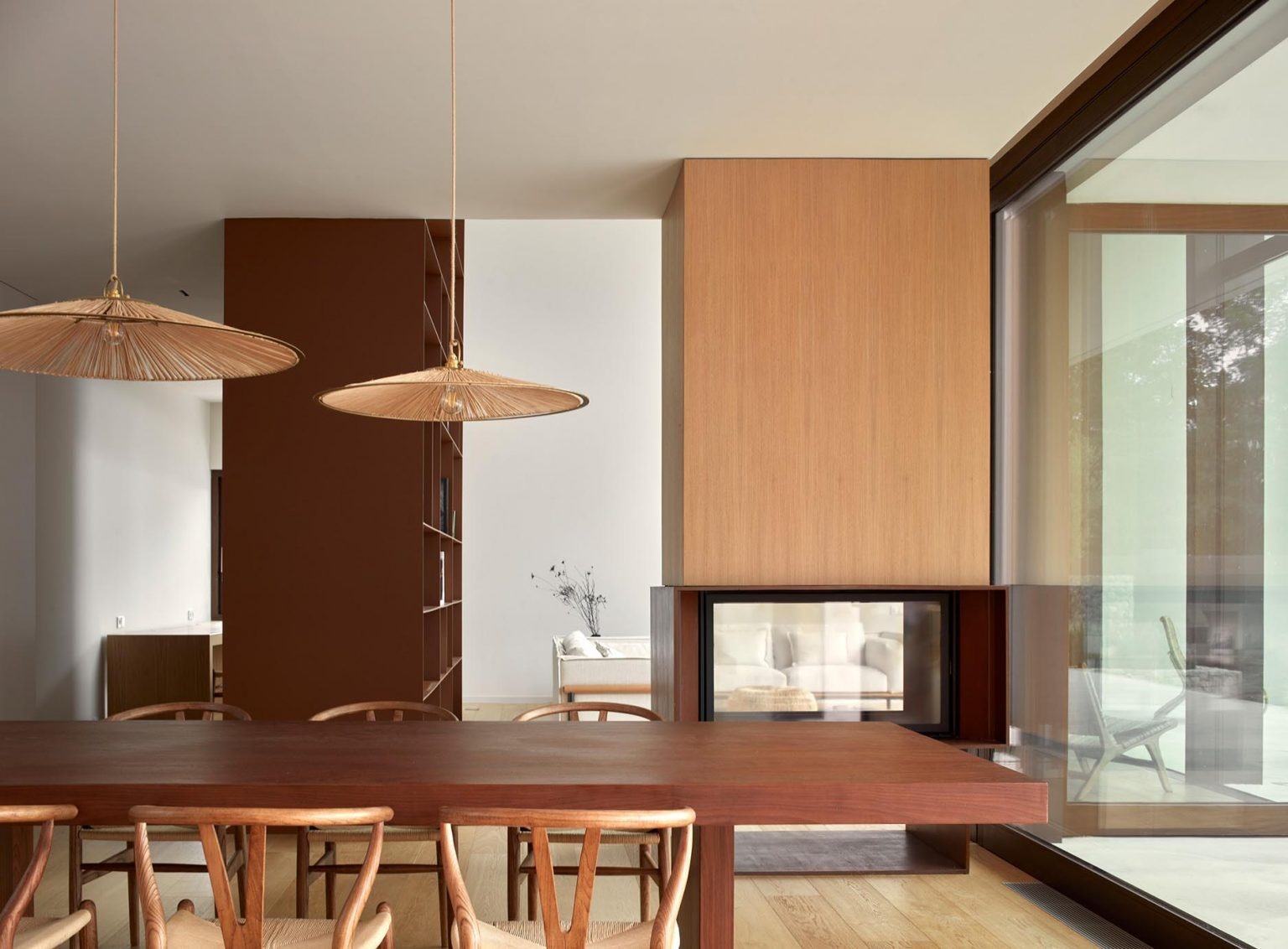 Warm wood interiors, a double-height living room, and huge forest-facing windows define this modern home near Barcelona.