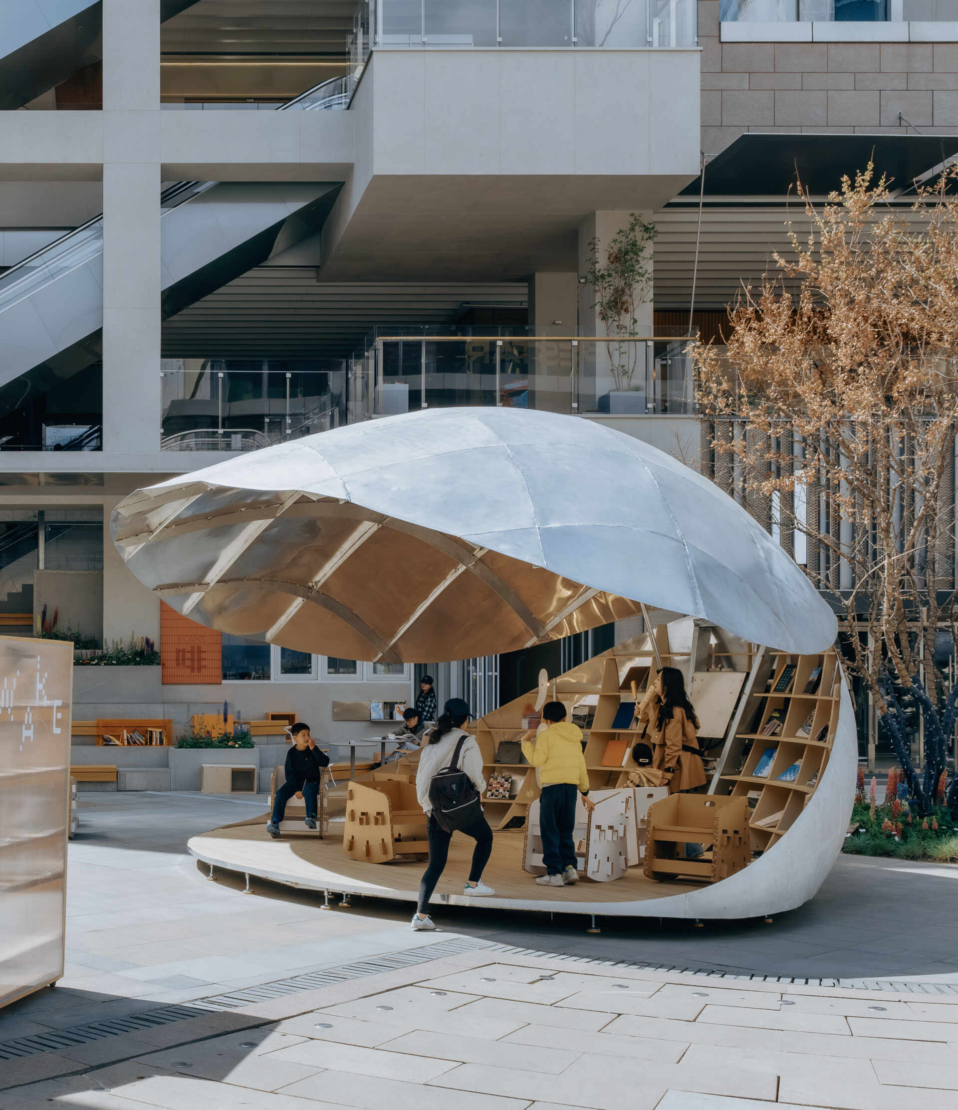 A shell-inspired pavilion in Beijing by LUO Studio opens and closes to create a flexible public space for reading, gathering, and events, bringing movement and interaction into the heart of a busy plaza.