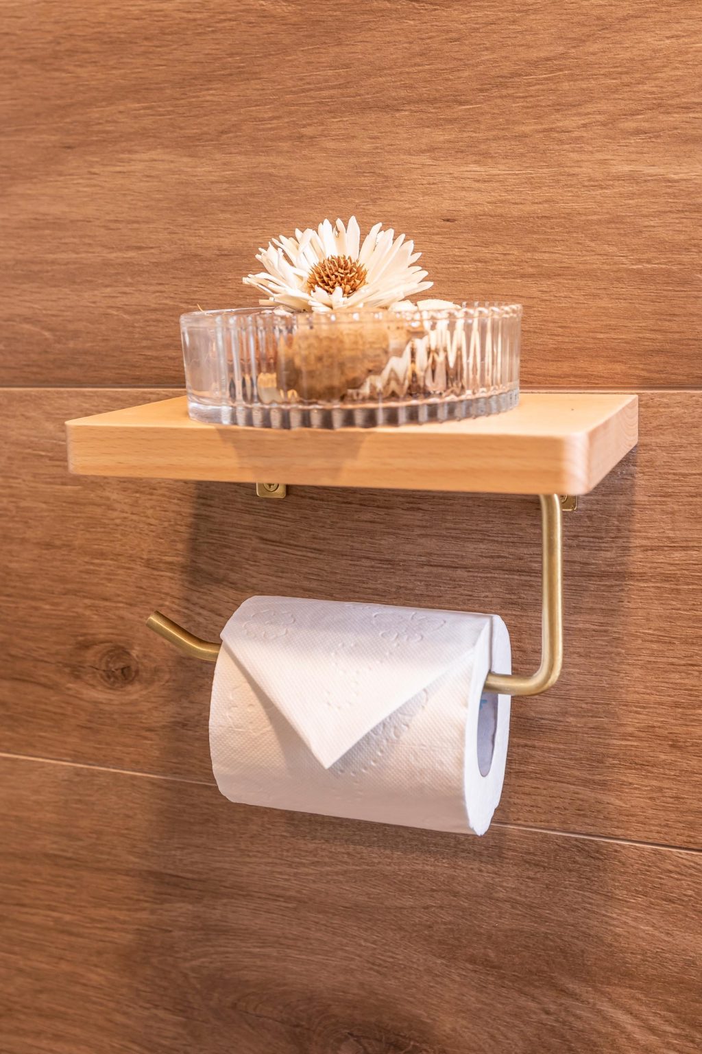 Wood accents and a glass-enclosed shower give this compact apartment bathroom a clean and modern look.