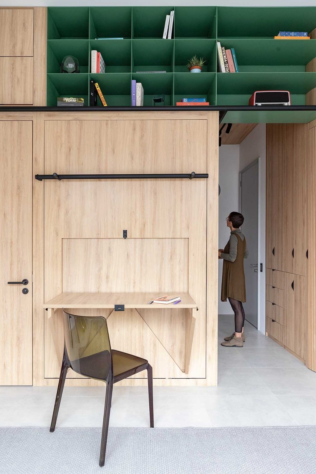 This ingenious micro apartment features furniture that transforms throughout the day, converting a bedroom into a workspace with a simple fold-down mechanism.