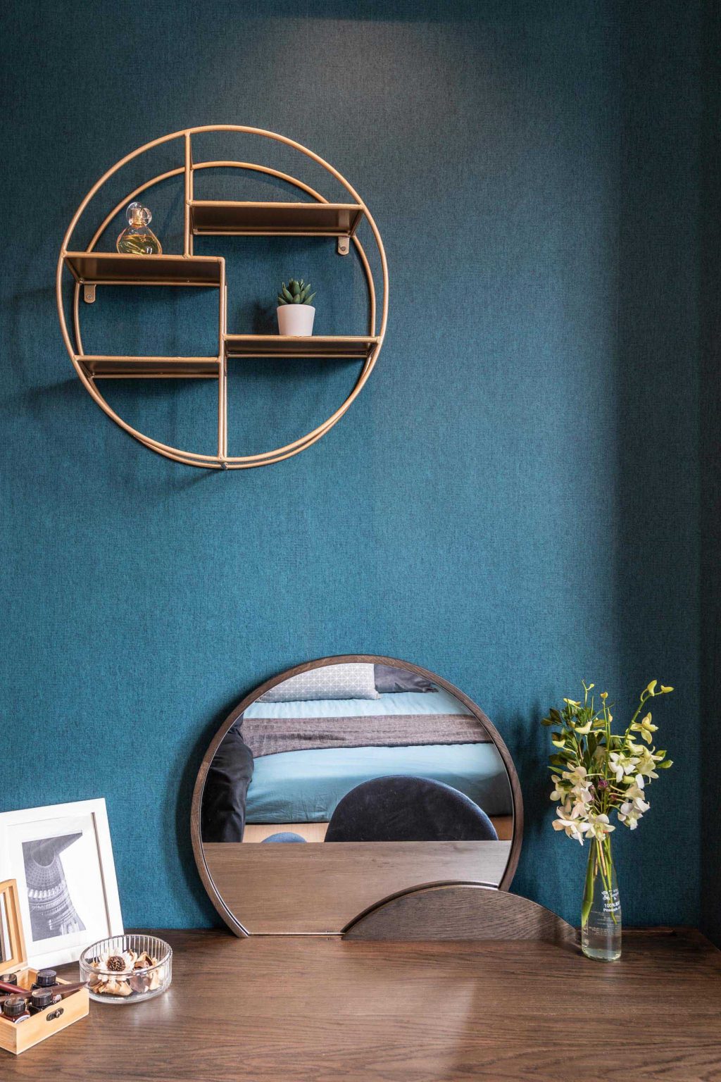 Blue textured wallpaper and a built-in window seat create a cozy workspace inside this small modern apartment in Hong Kong.