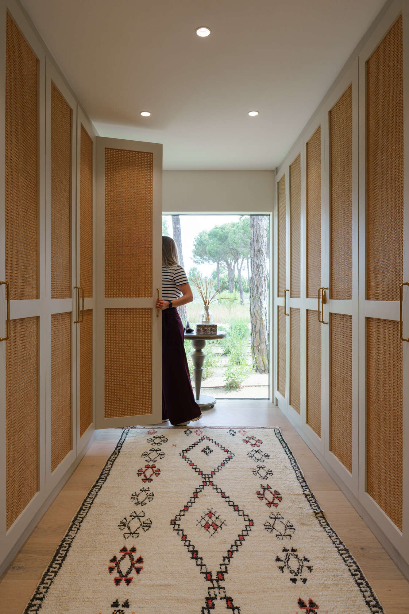 Warm timber details and minimalist finishes define this elegant walk-in closet inside the master suite of Casa na Comporta.