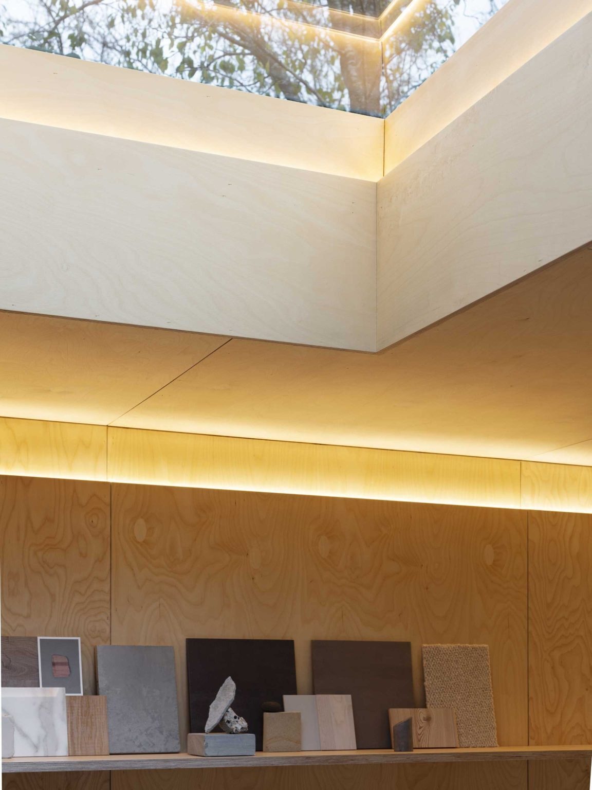 A simple kitchenette, a skylight, and continuous shelving help maximize light and storage in this small studio office.