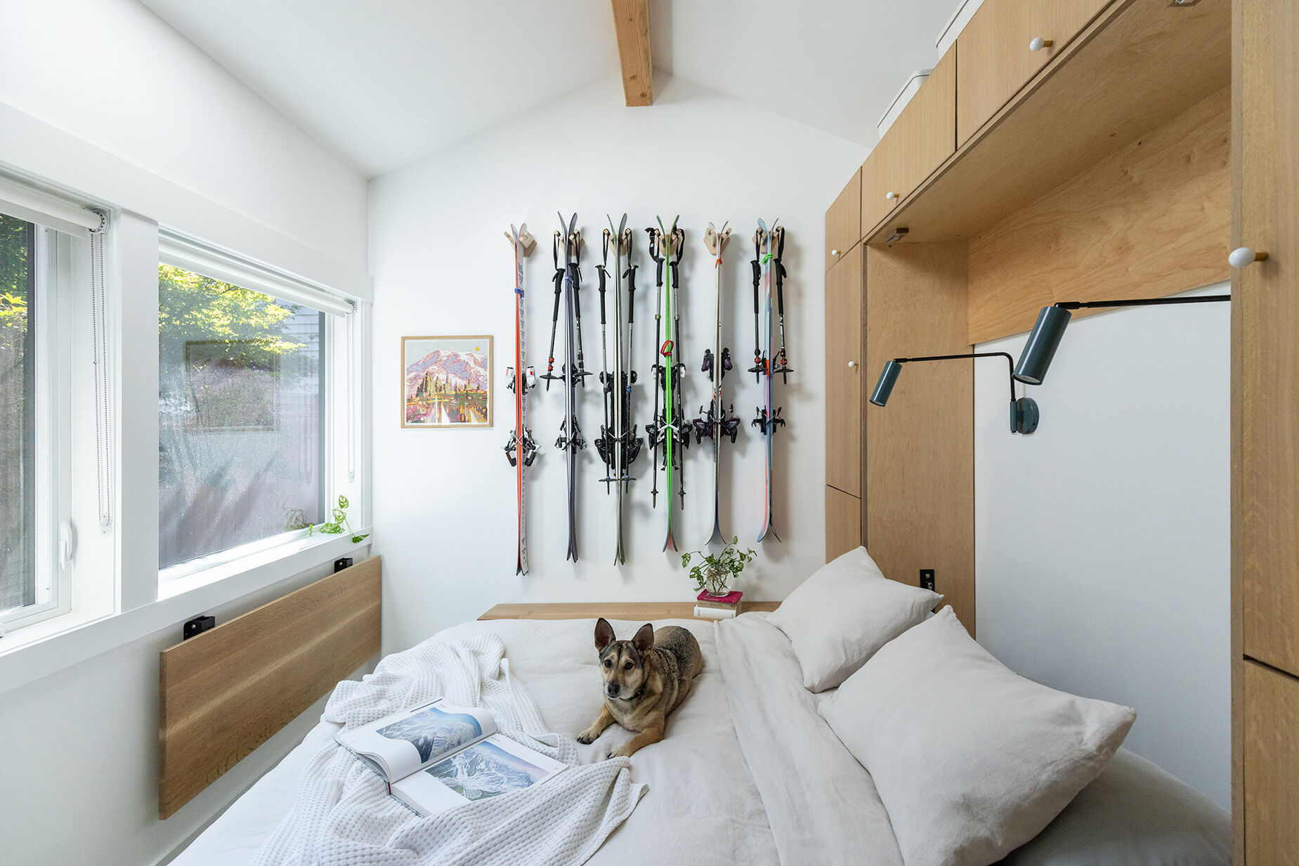 Custom white oak cabinetry hides a Murphy bed, organizes outdoor gear, and keeps this small studio feeling bright and uncluttered.