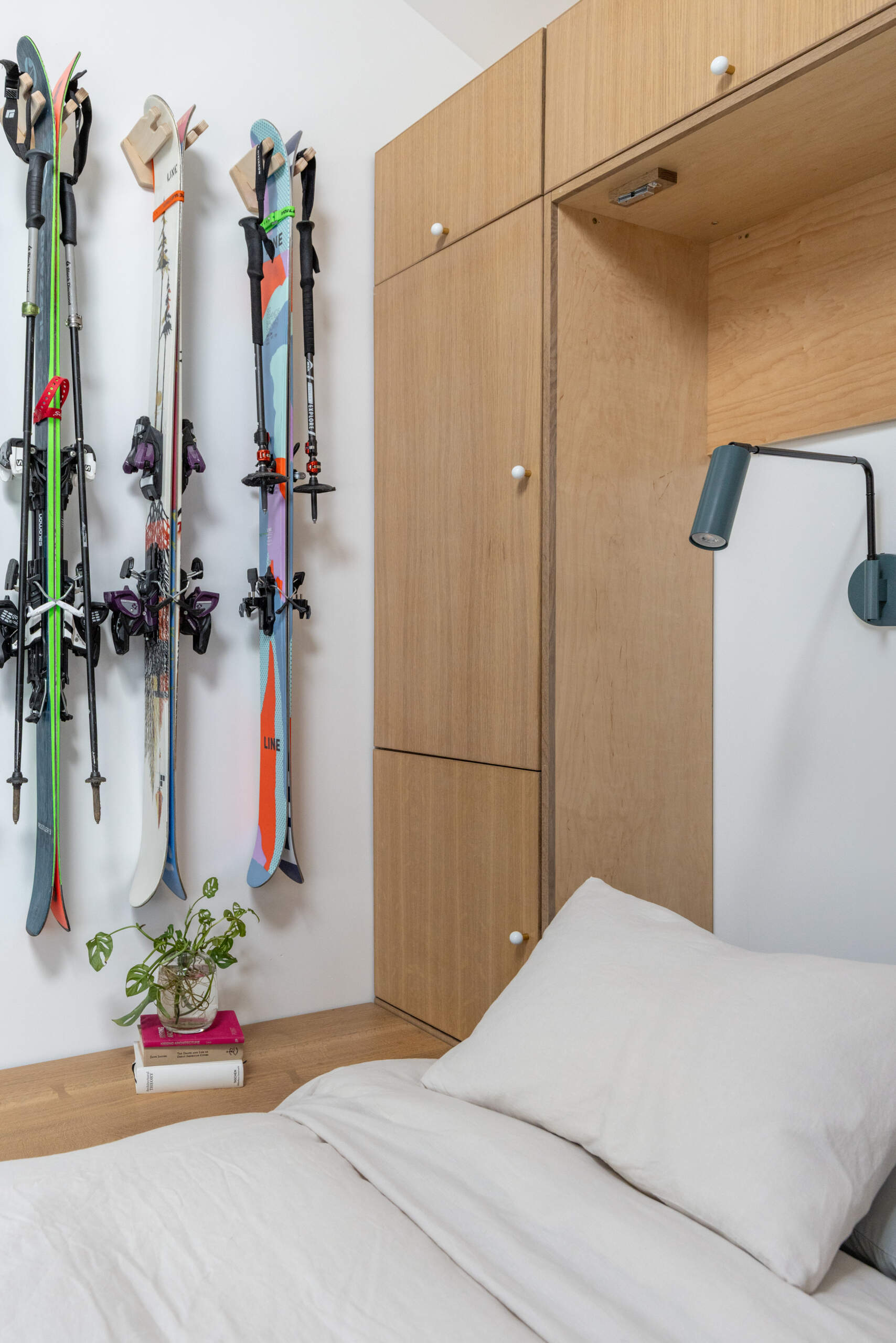 Custom white oak cabinetry hides a Murphy bed, organizes outdoor gear, and keeps this small studio feeling bright and uncluttered.