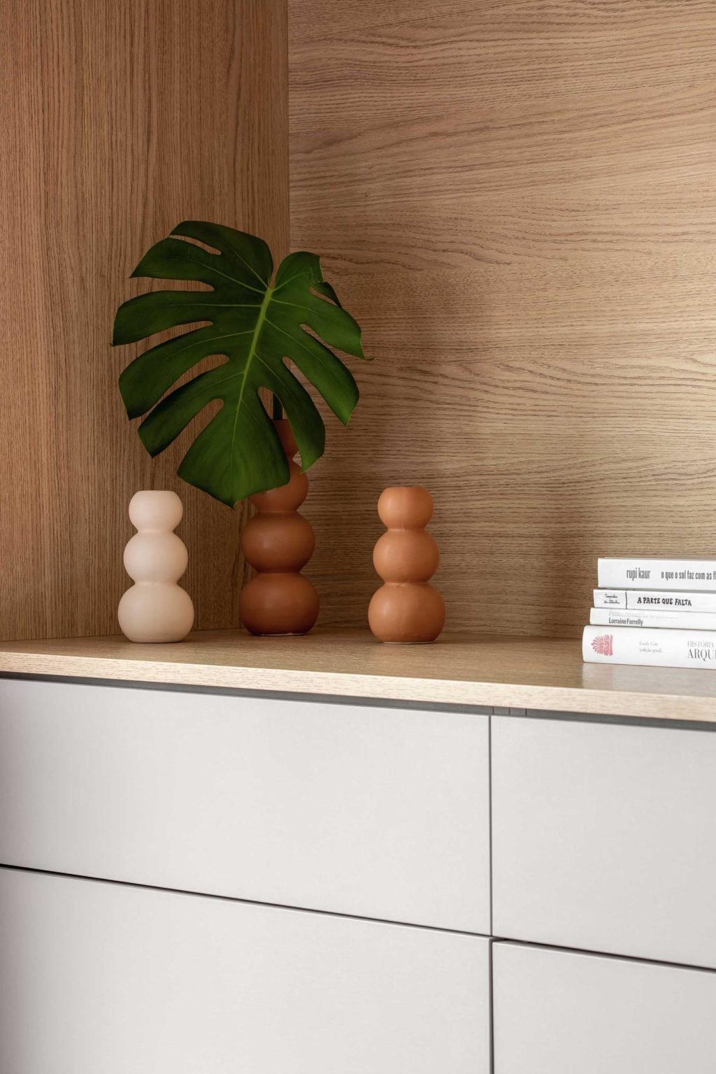 A full-width wood headboard and integrated storage solutions give this primary bedroom a warm, clean, and highly functional design.