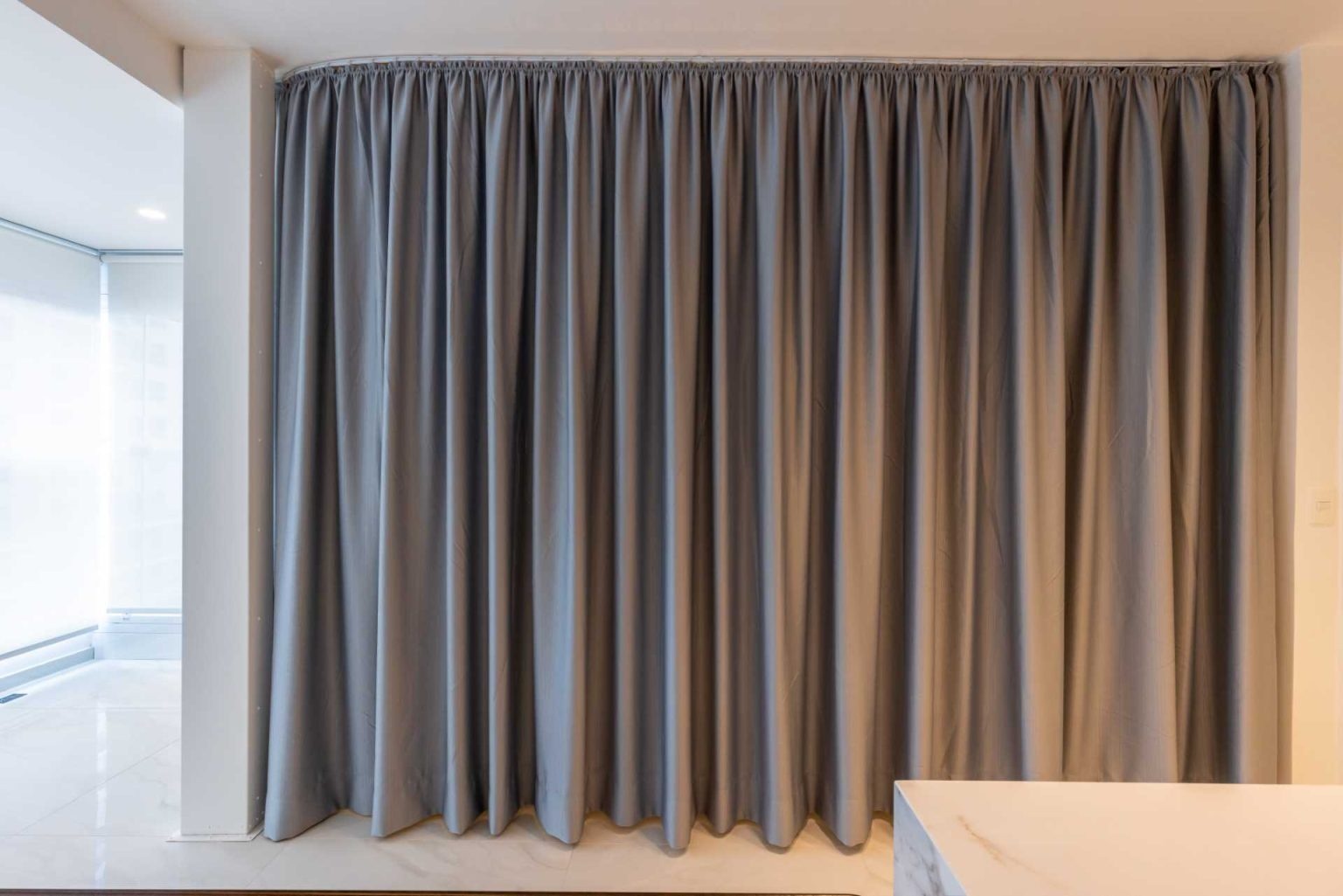 These floor-to-ceiling bedroom curtains can hide an entire sleeping area in seconds. A smart design idea that adds privacy without closing off the apartment.
