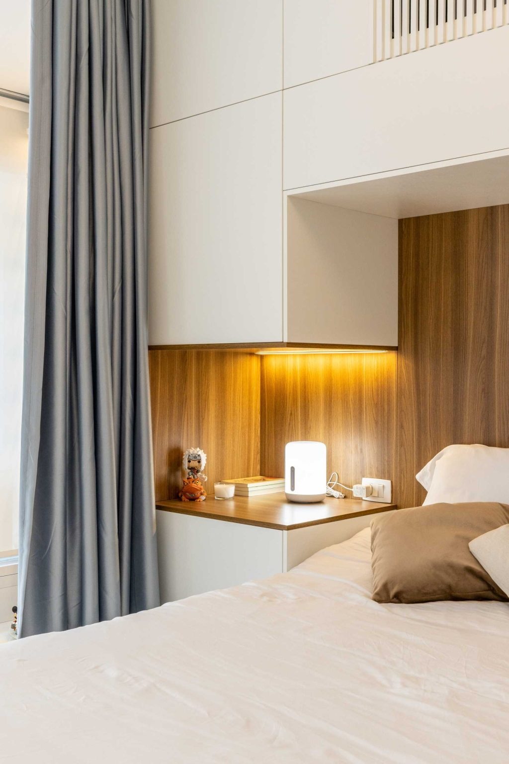 Hidden lighting, built-in storage, and integrated bedside tables make this compact bedroom feel organized and inviting without wasting space.