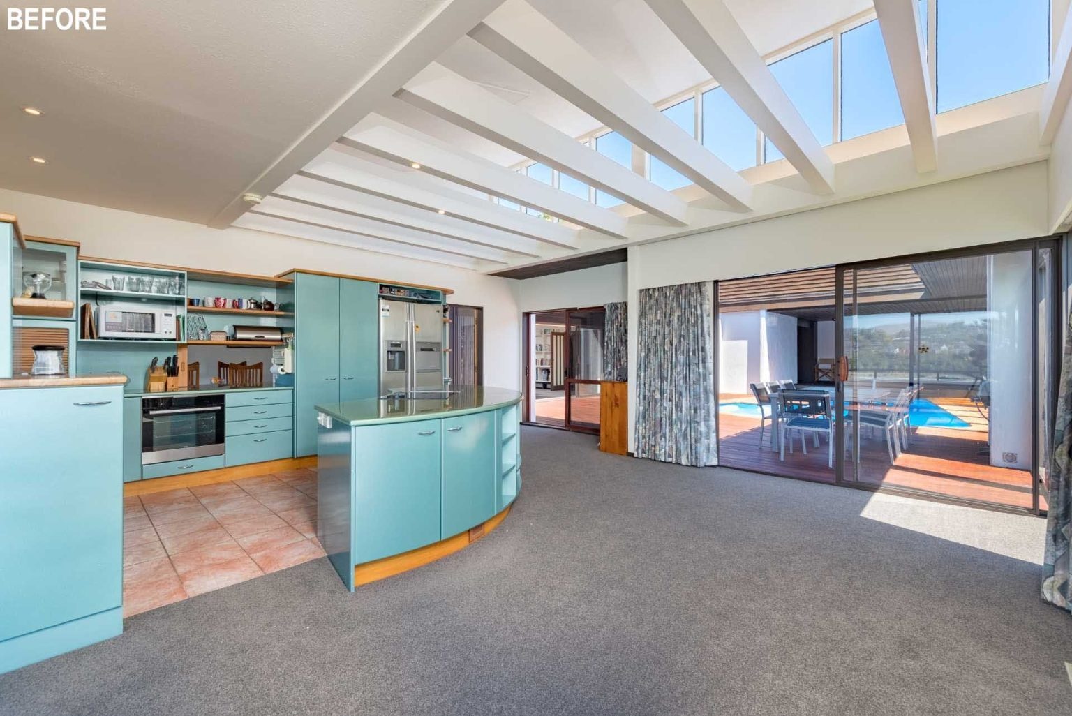 BEFORE - A complete redesign of the kitchen, dining, and living spaces introduces black cabinetry, streamlined layouts, and seamless connections to the courtyard and pool.