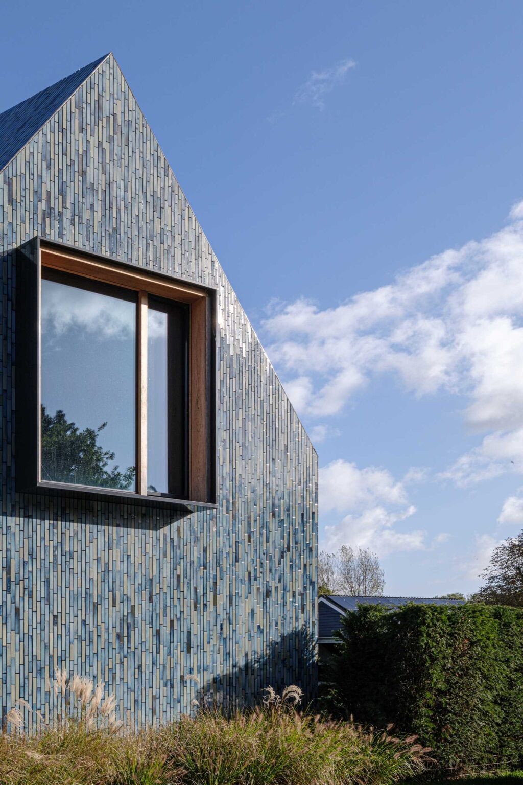 Instead of mixing different exterior materials, Mecanoo wrapped this entire villa in custom glazed ceramic tiles. The seamless finish stretches from the walls to the roof, giving the home a bold, unified appearance.