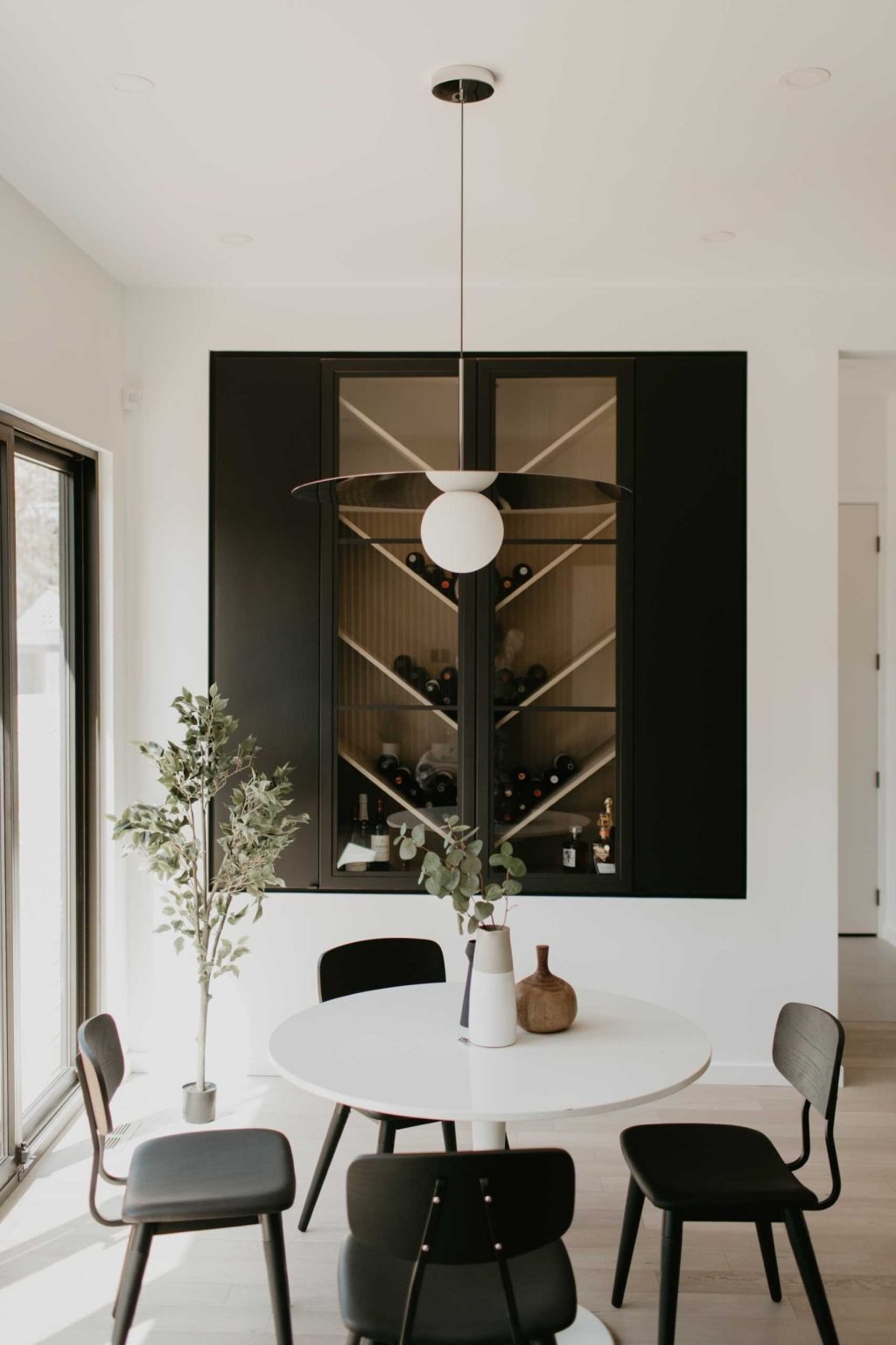 Wood slats, black cabinetry, a chevron wine display, and open-plan living make this modern family space full of inspiring design ideas.