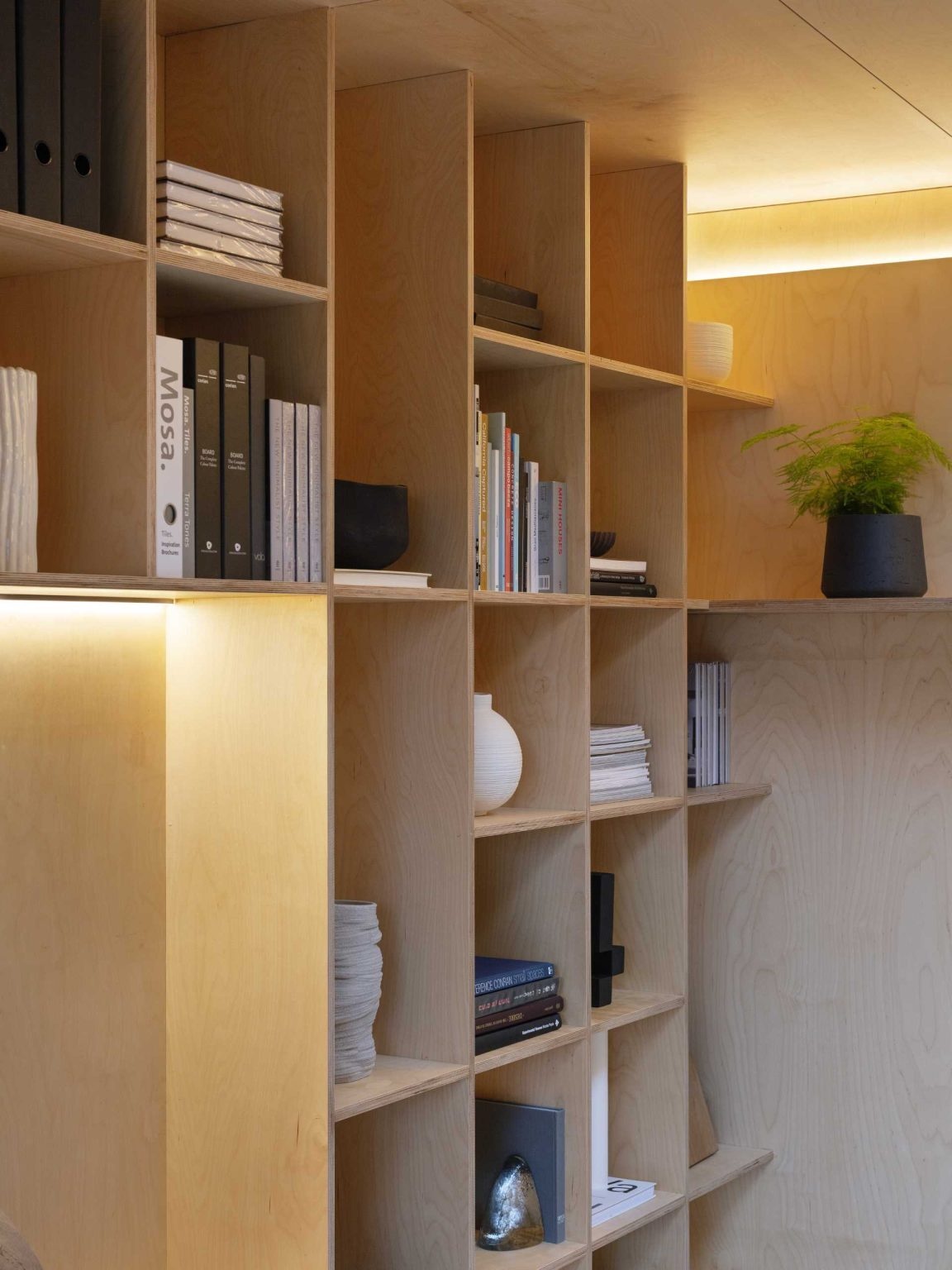 A full wall of bookshelves with an integrated seating nook turns storage into a functional design feature.