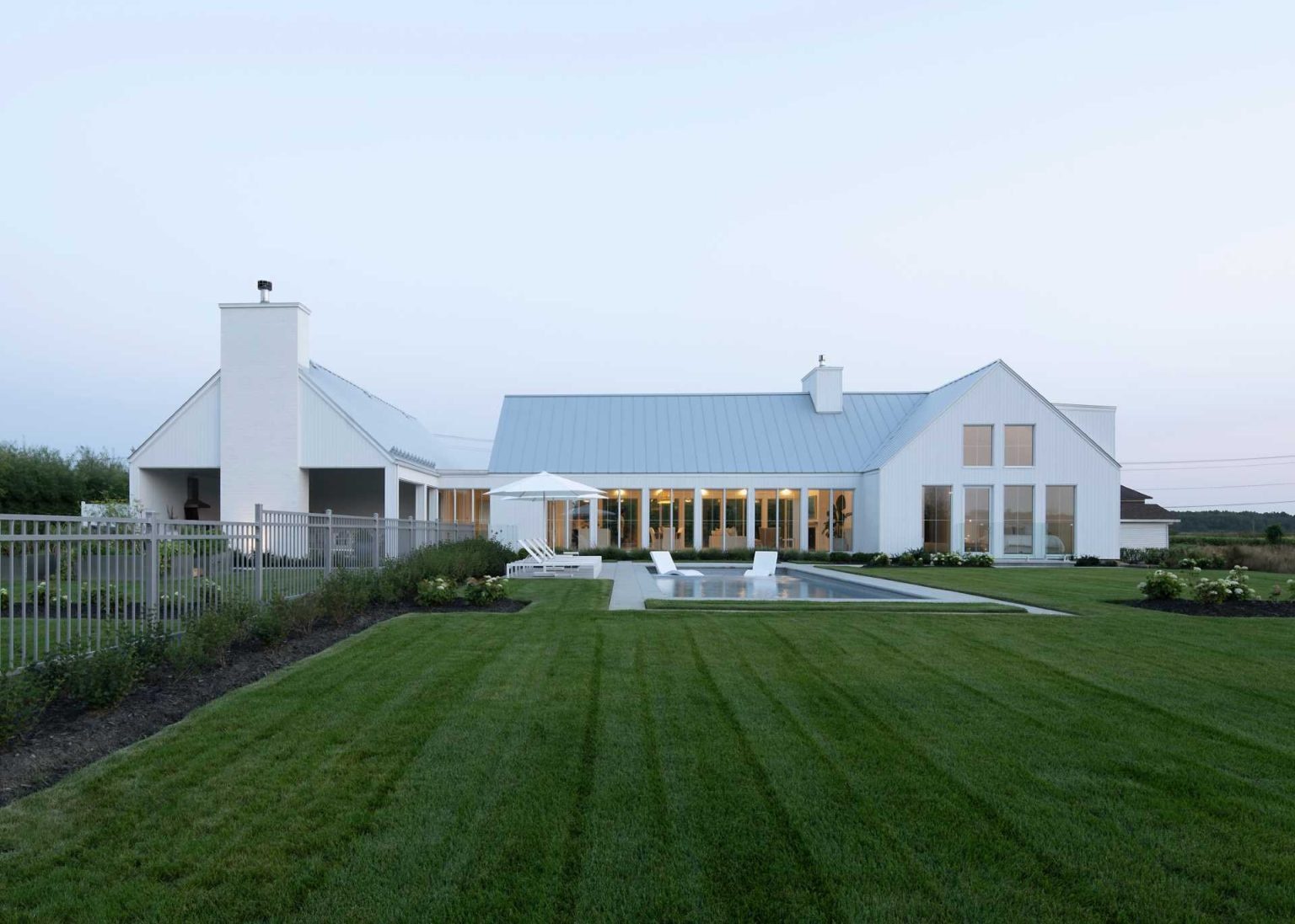 Covered outdoor living, a barbecue area, and a pathway leading to the pool make this Quebec family home perfect for entertaining outdoors.